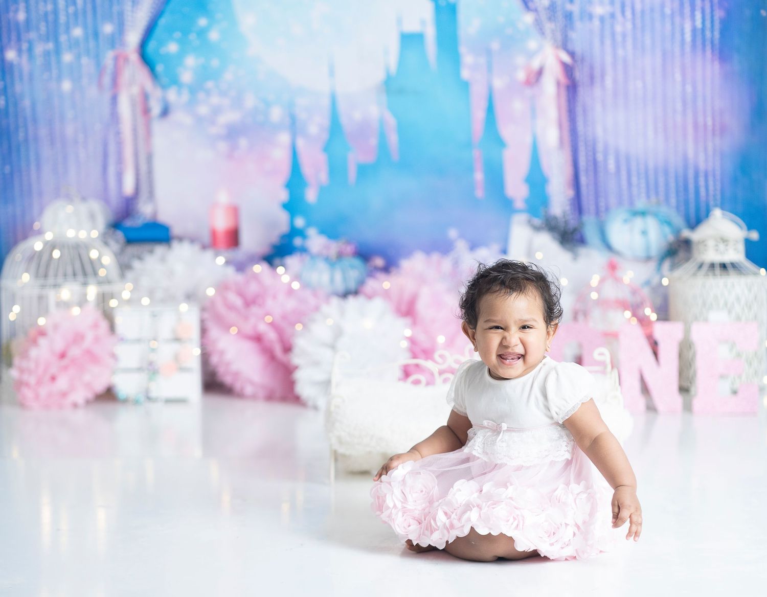 Princess themed birthday setup with castle backdrop and pink tulle decorations.