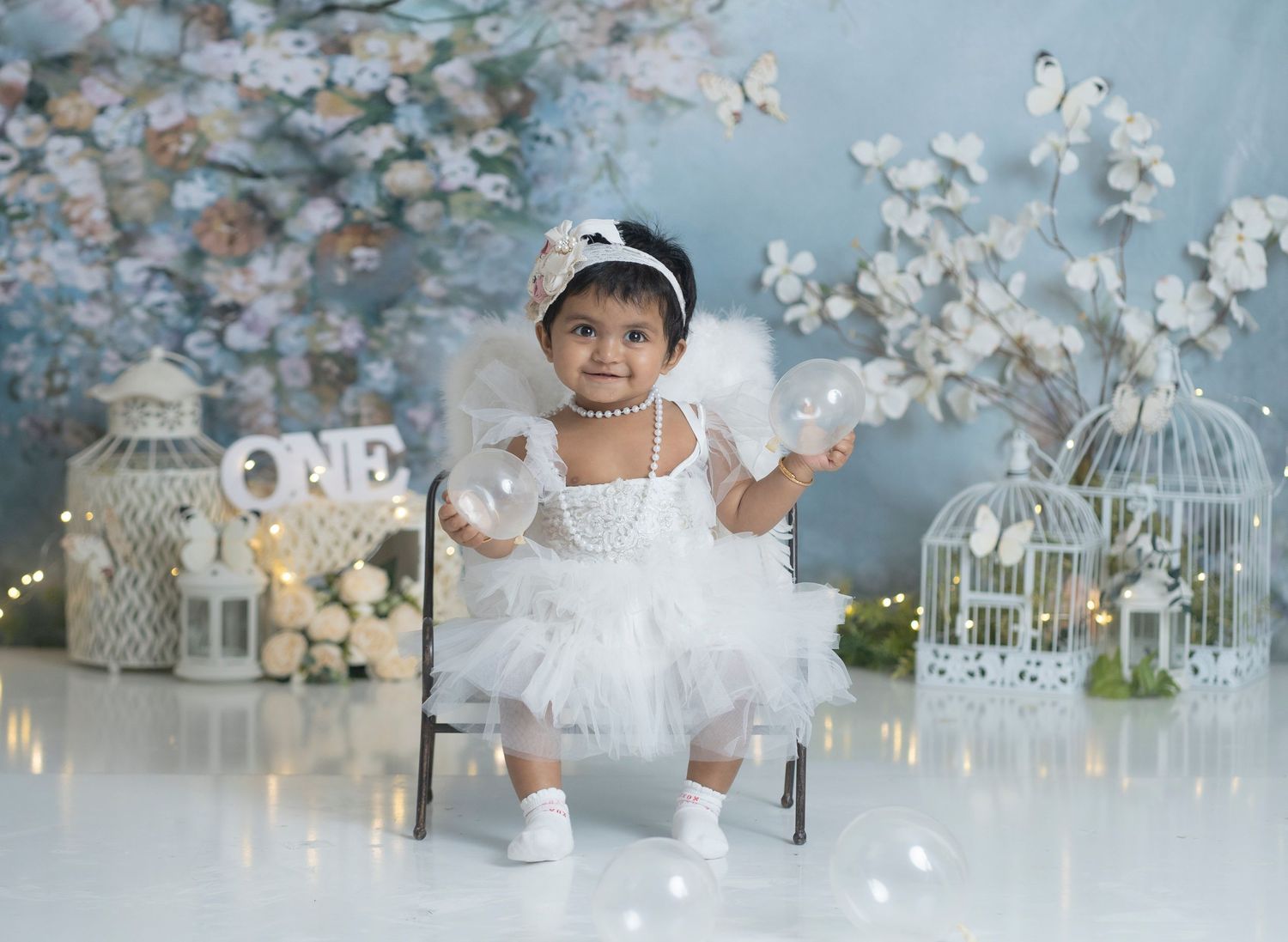 White tutu dress photoshoot with birdcages and cherry blossoms in dreamy spring setting.