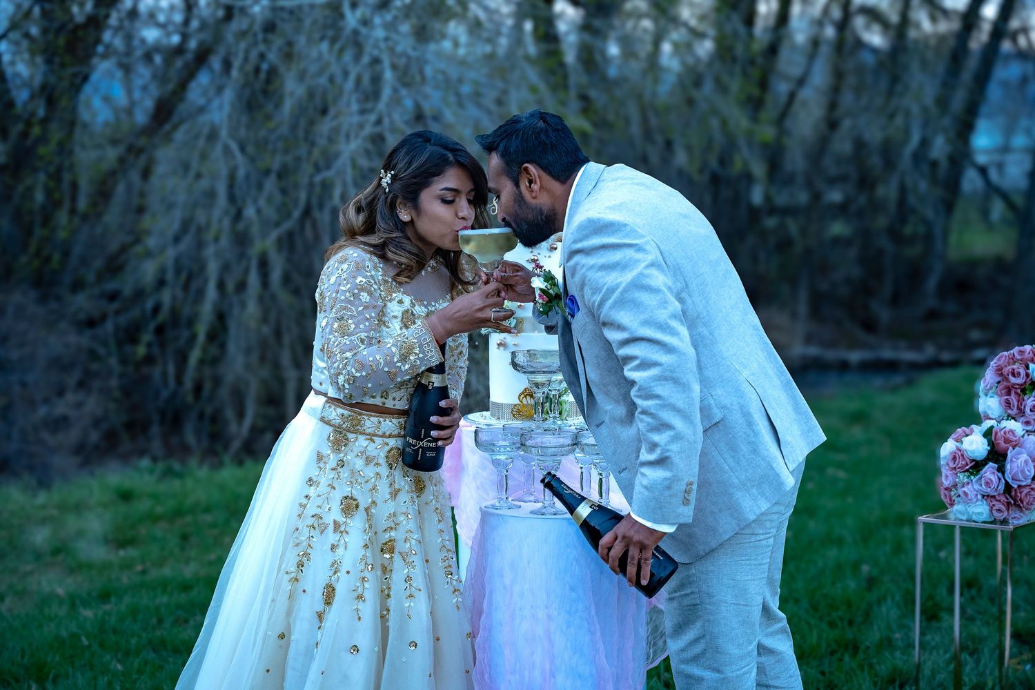 Romantic moment at twilight wedding reception with decorative cake display.