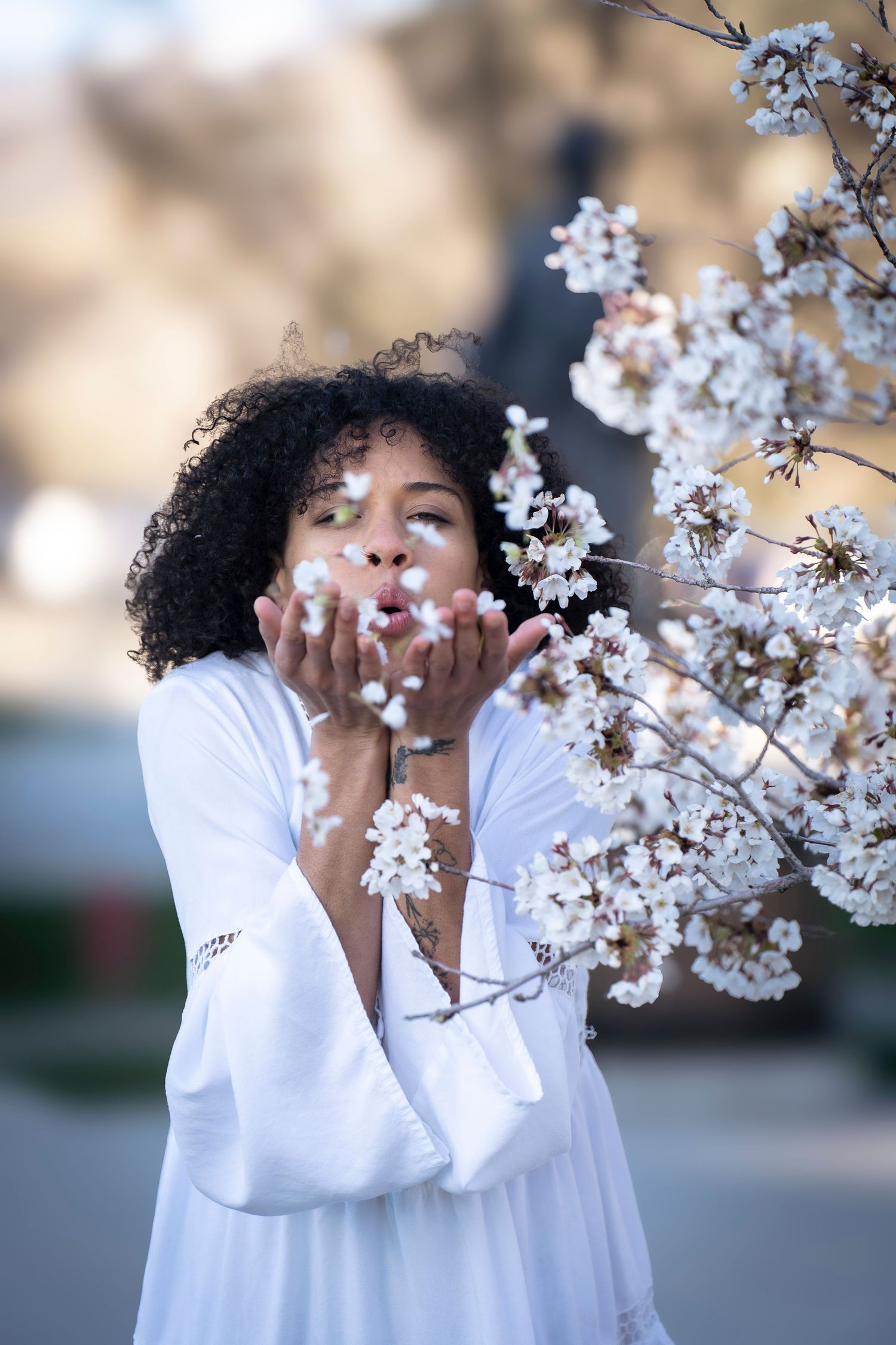 White flowers frame a dreamy spring portrait in a flowing white dress.