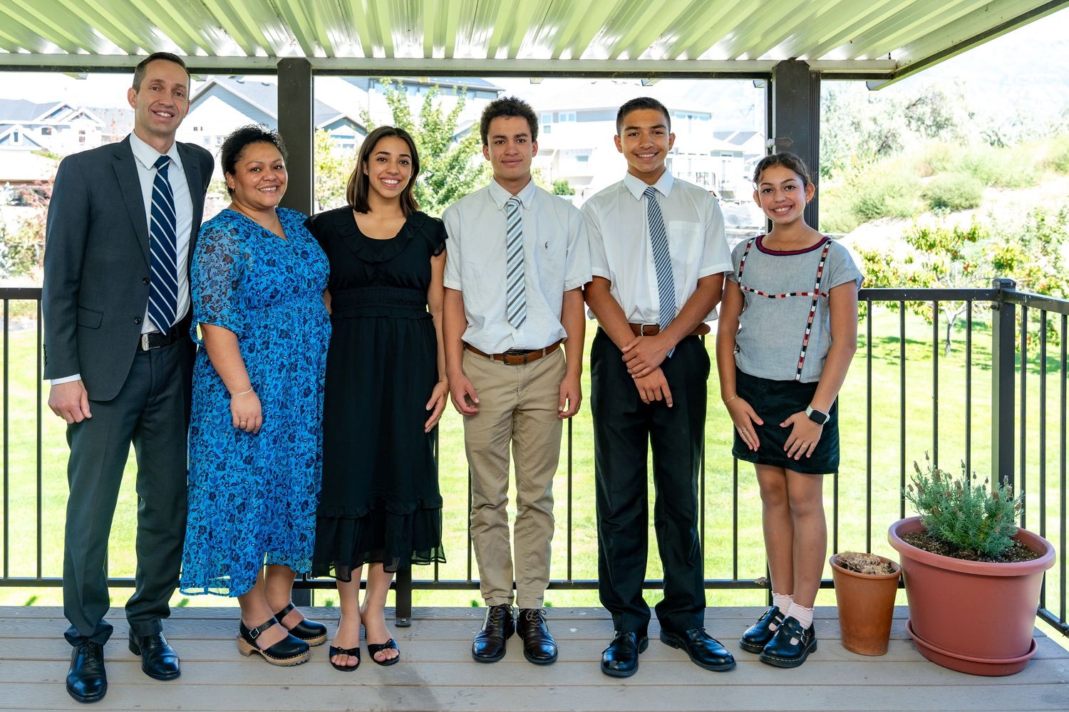 Group photo of people in business attire standing under an outdoor pavilion.