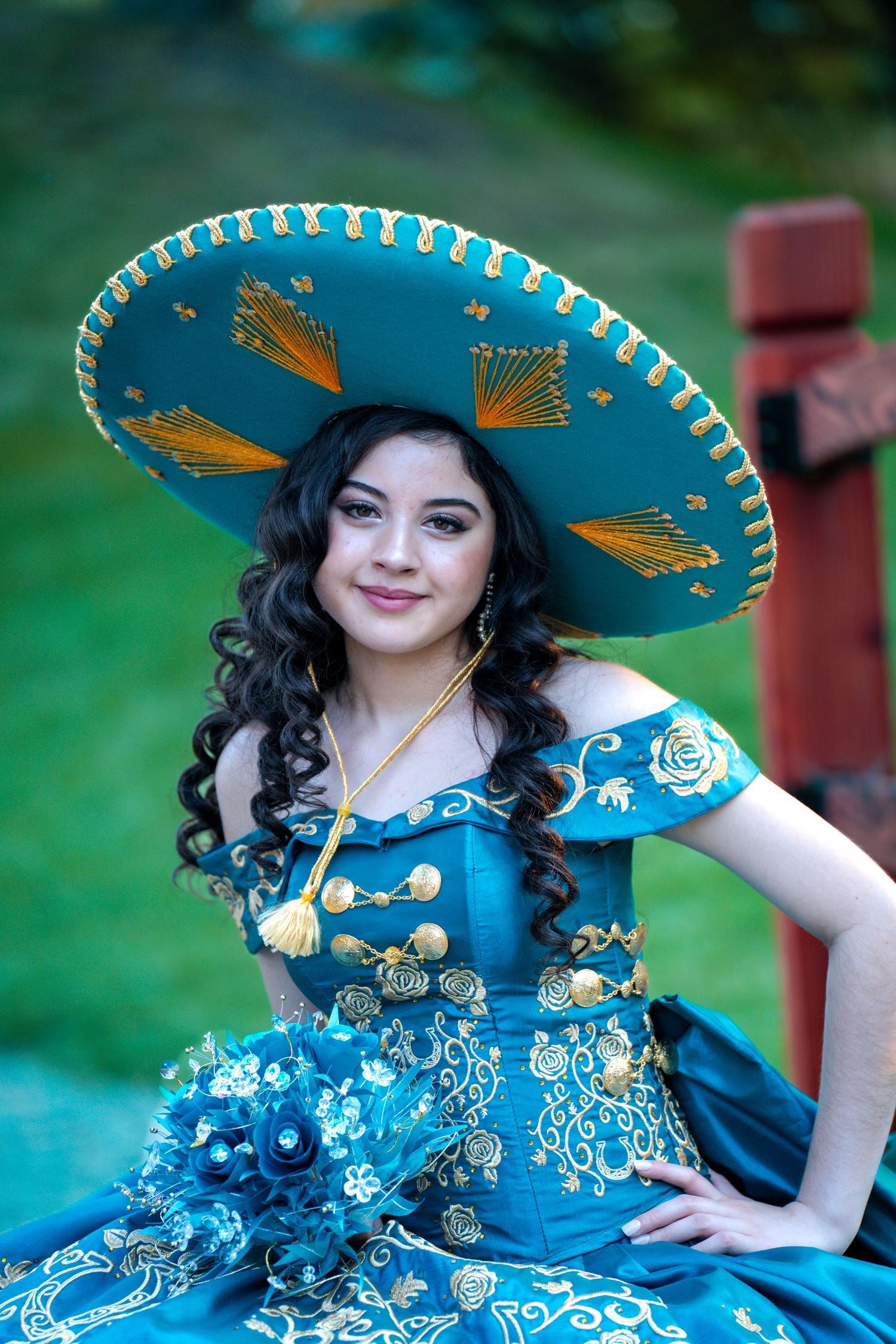 Detailed shot of turquoise quinceañera dress with matching embellished sombrero.
