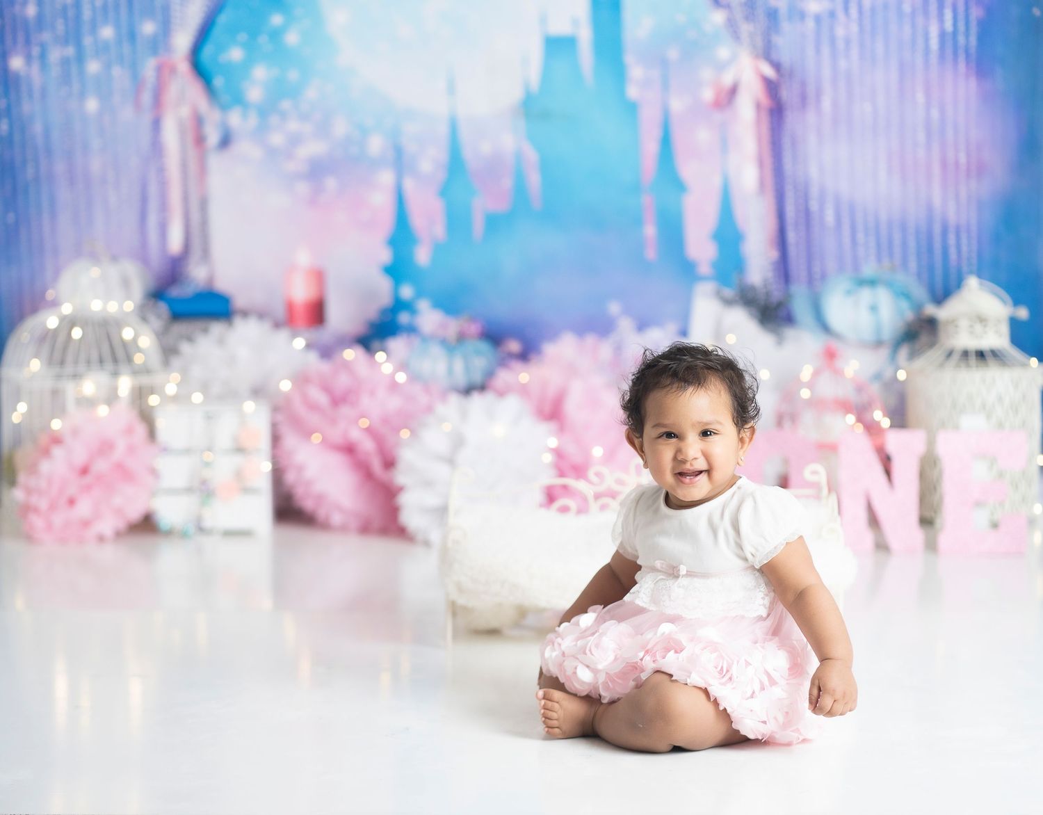 Fantasy-themed birthday setup with castle silhouette backdrop and pink decorative elements.
