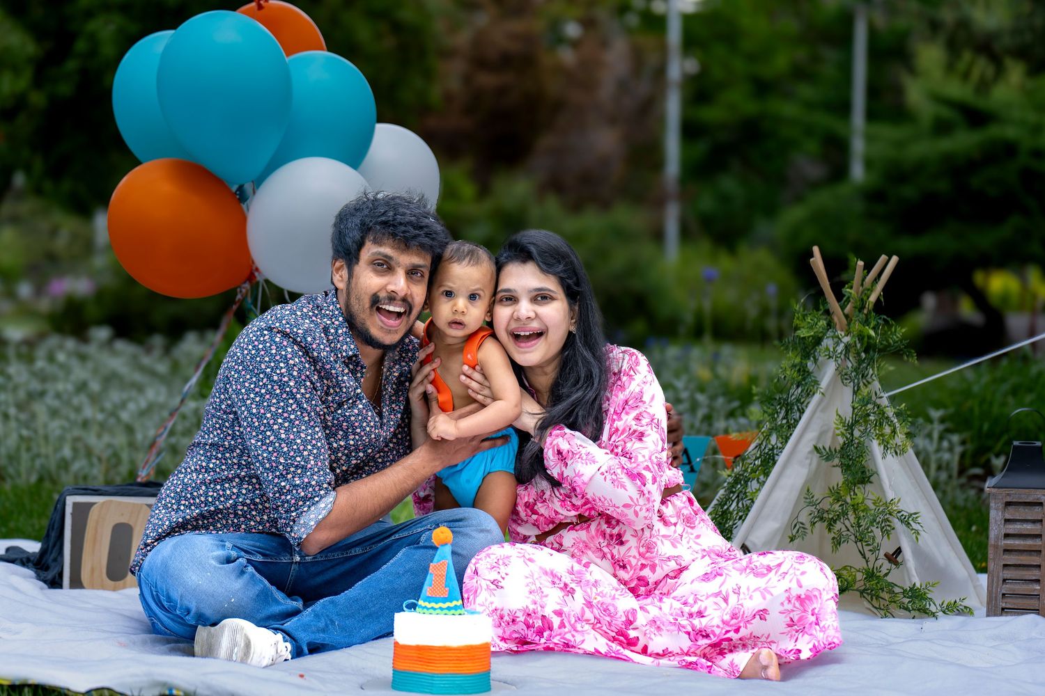 A celebration scene with colorful balloons and a birthday cake on a picnic blanket.