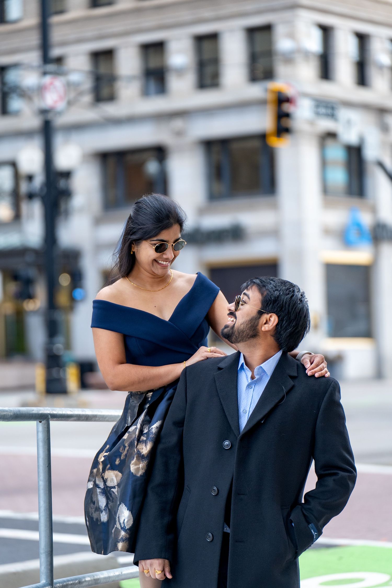 Happy couple sharing a tender moment on urban street corner.