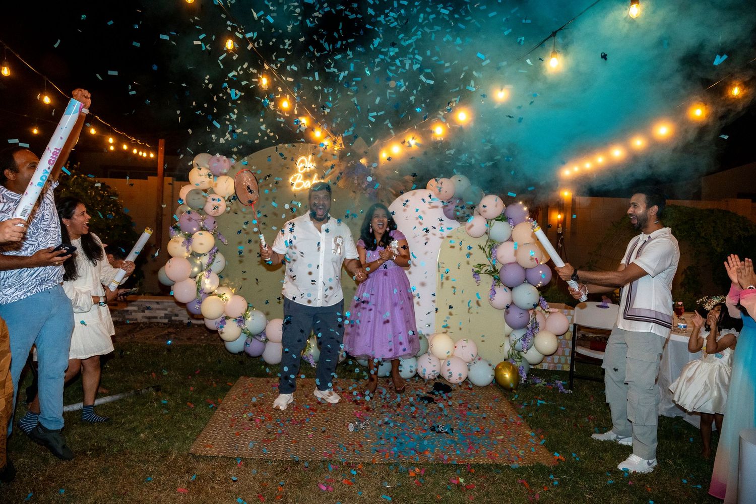 Festive outdoor party scene with confetti explosion and balloon decorations.
