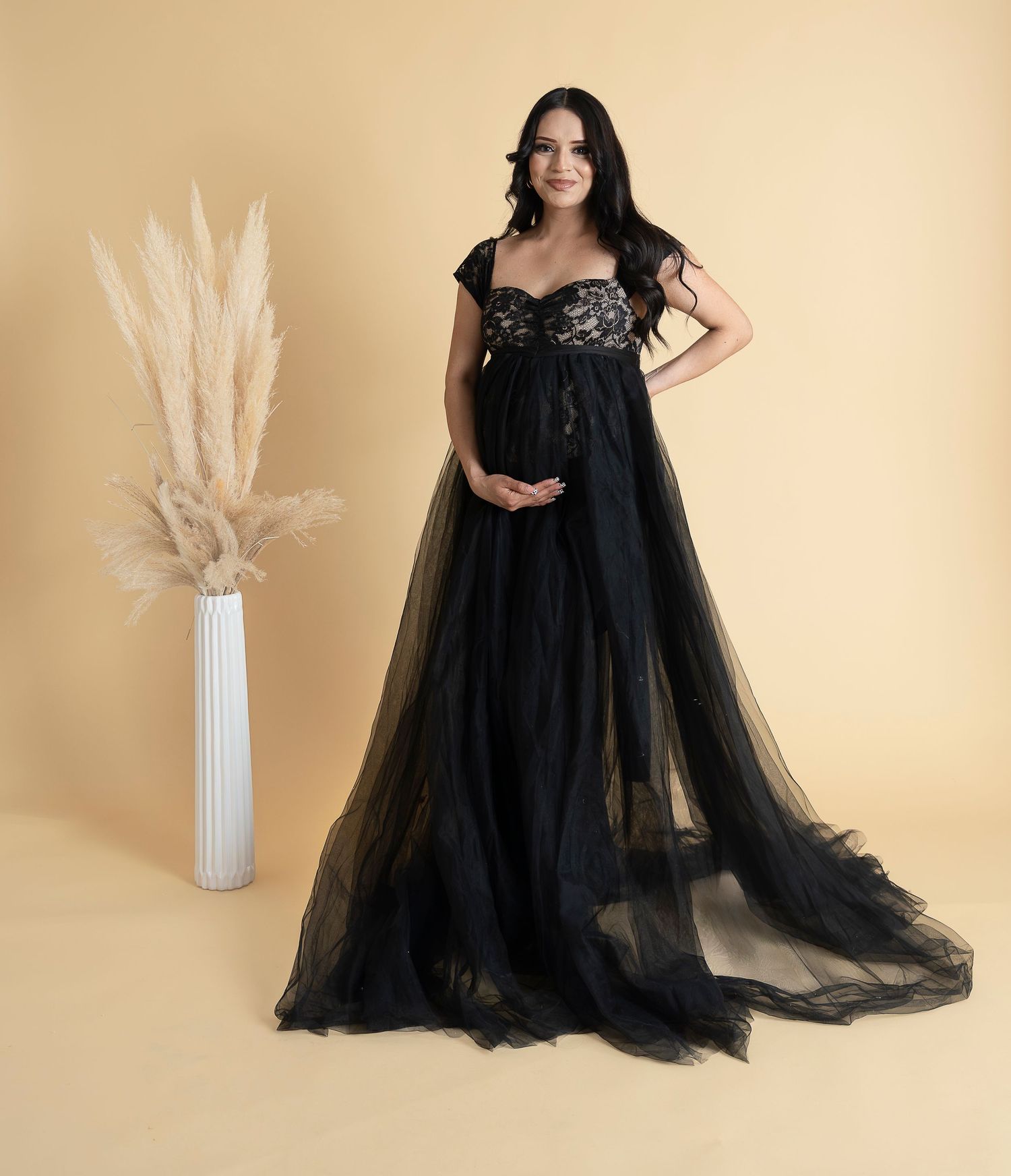 Dramatic maternity portrait in flowing black tulle gown with pampas grass decor.