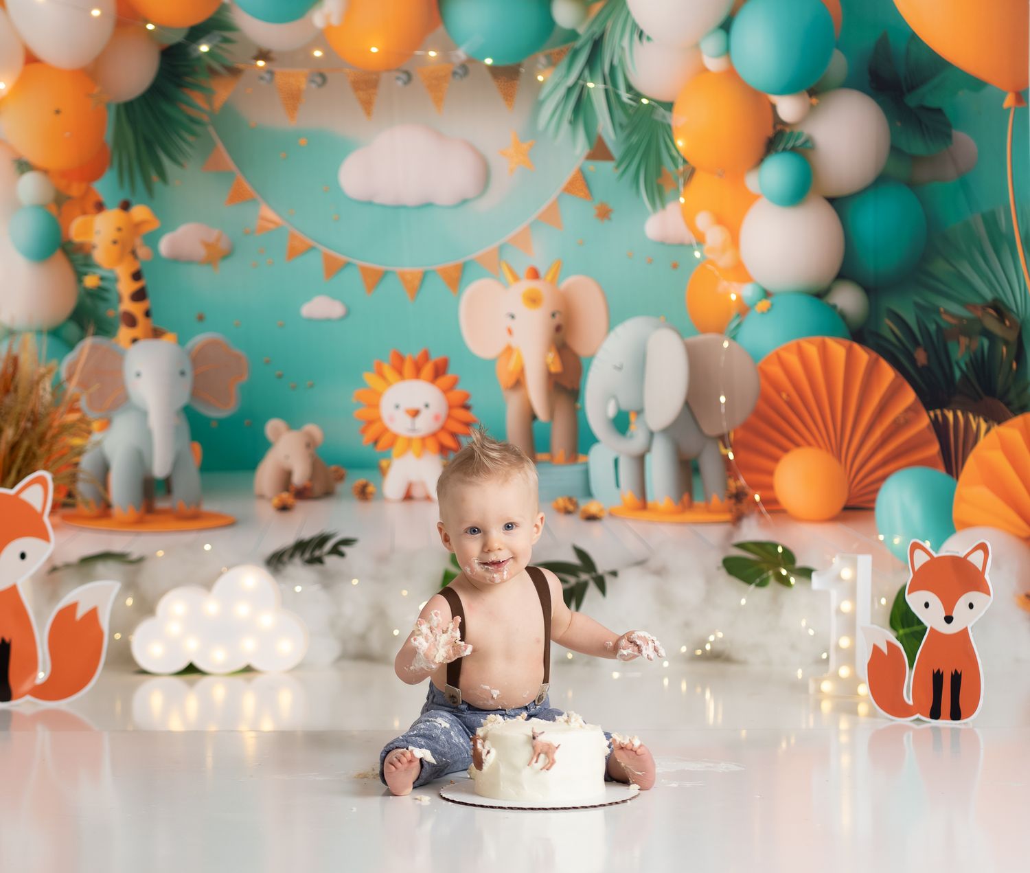 Safari themed first birthday setup with balloons, animal cutouts, and cake on white floor.