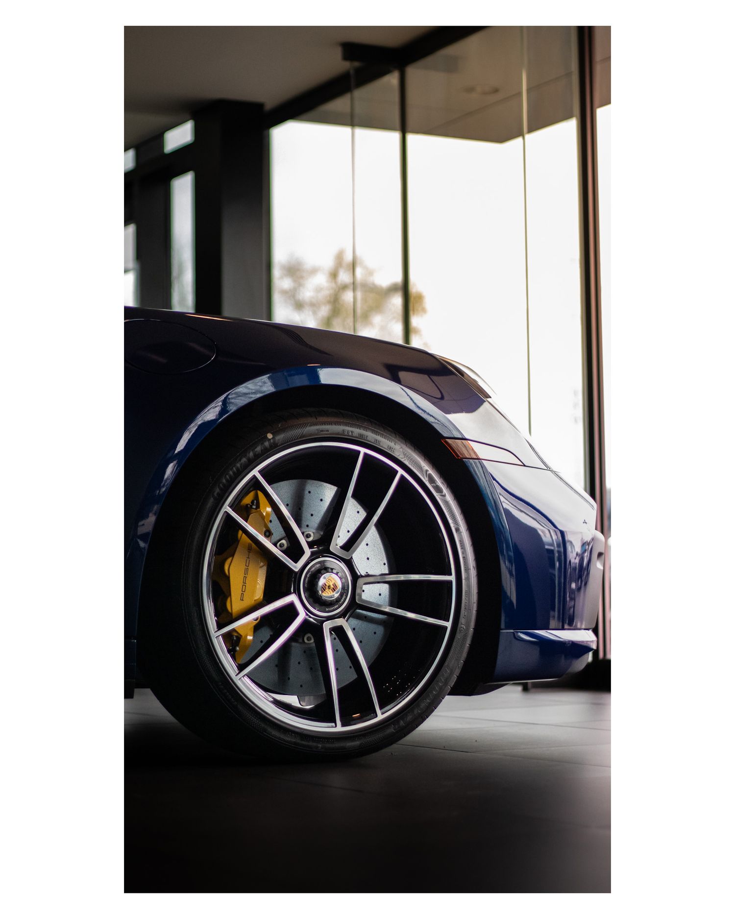 Close-up detail of luxury sports car wheel and brake caliper design.