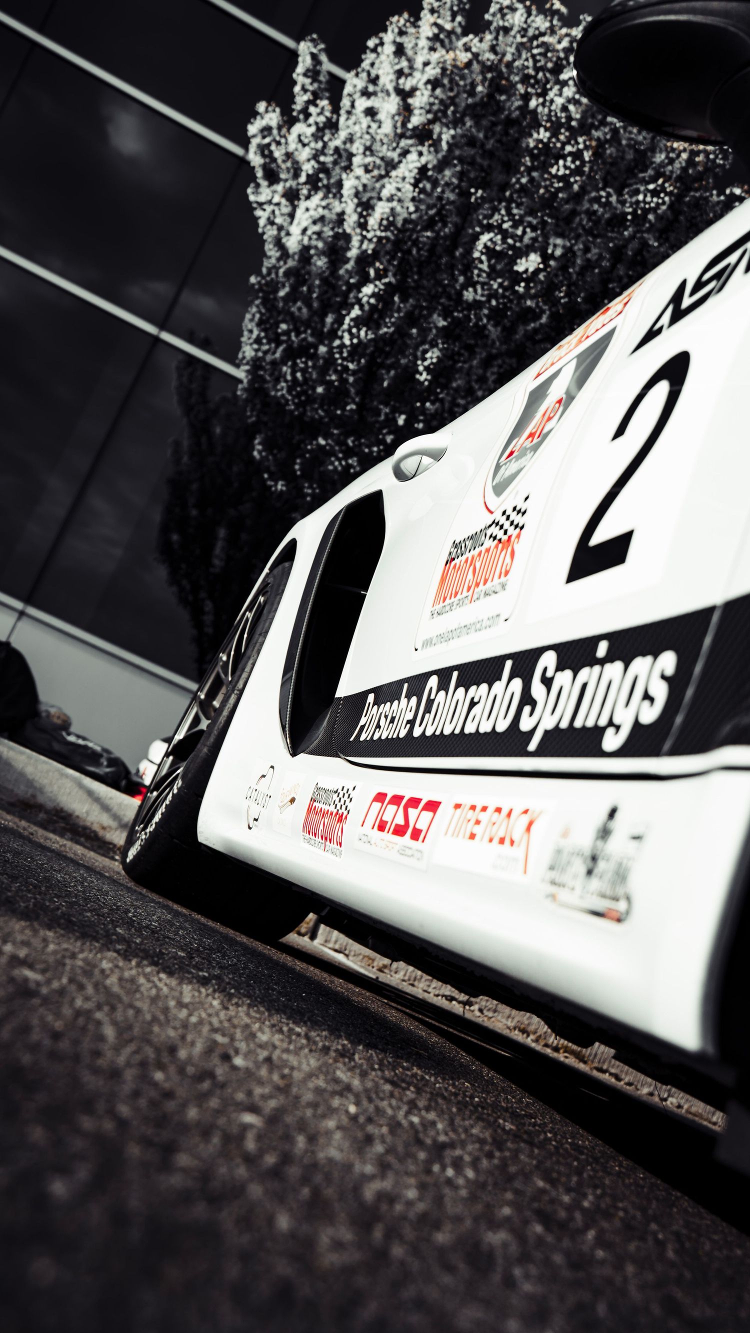Close-up view of white race car side panels with sponsorship text.