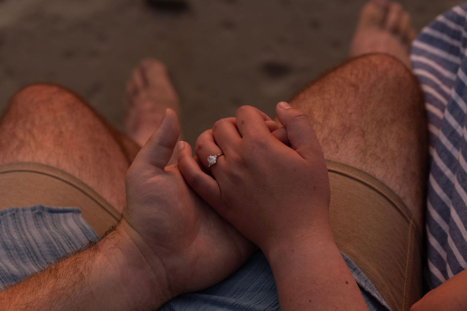 A close-up view of hands holding a bottle with both hands reaching for or adjusting it together.