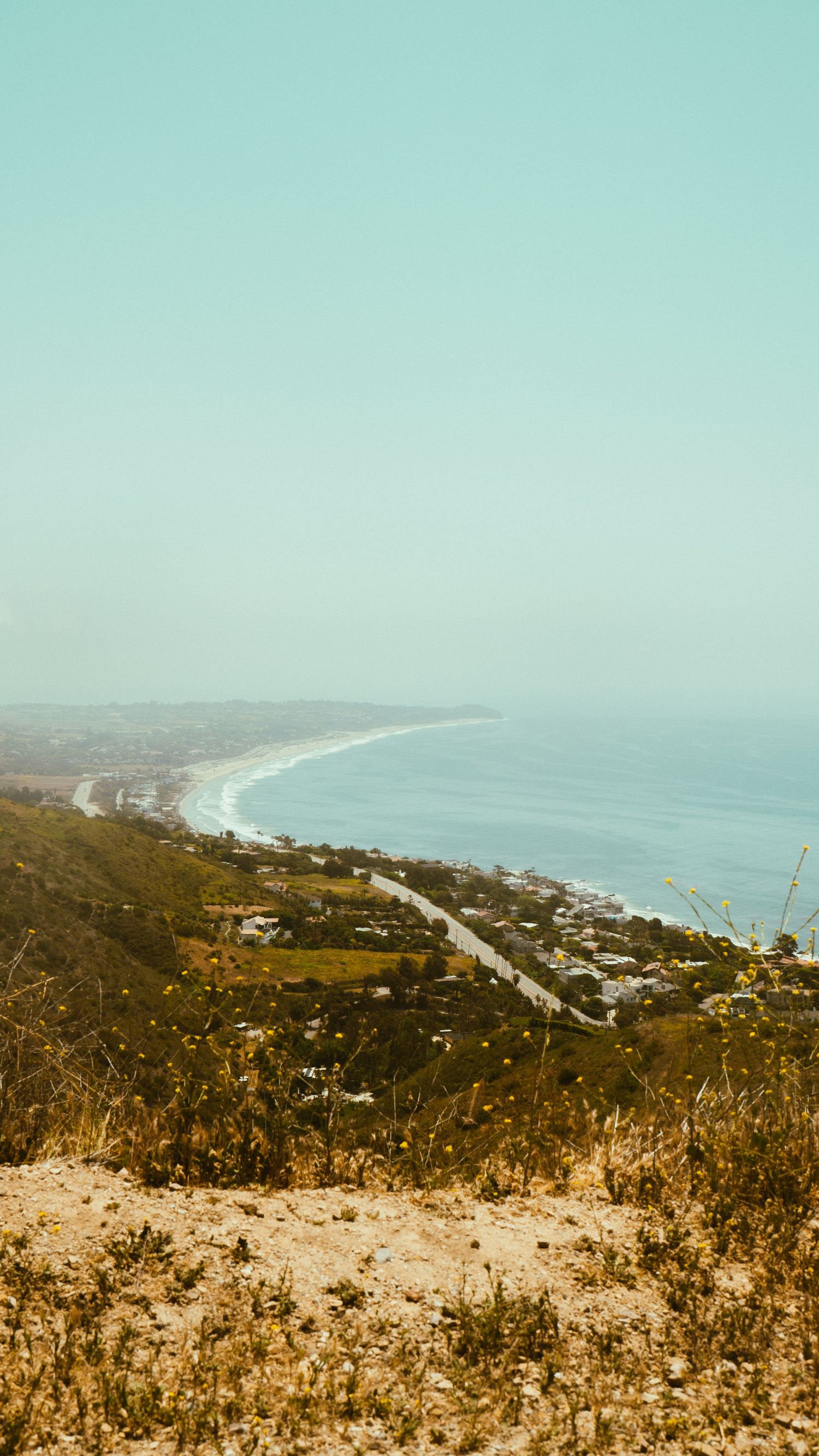 Sweeping vista of Pacific Coast Highway and beachside community from hilltop overlook.