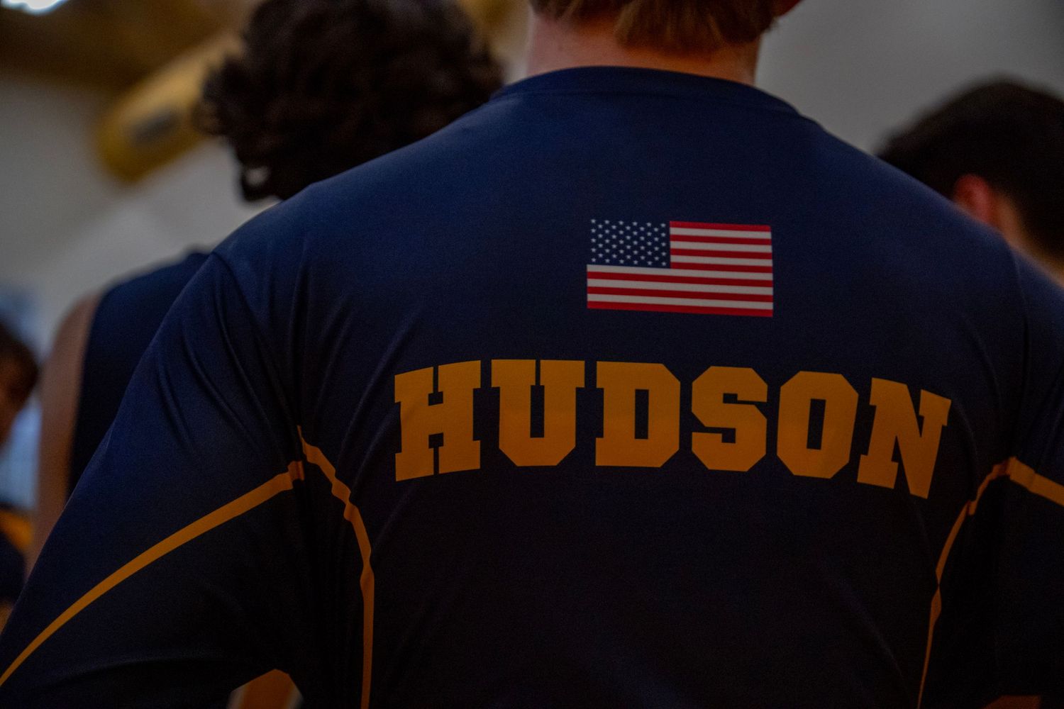Close-up of a Hudson team uniform with American flag patch during a volleyball match.