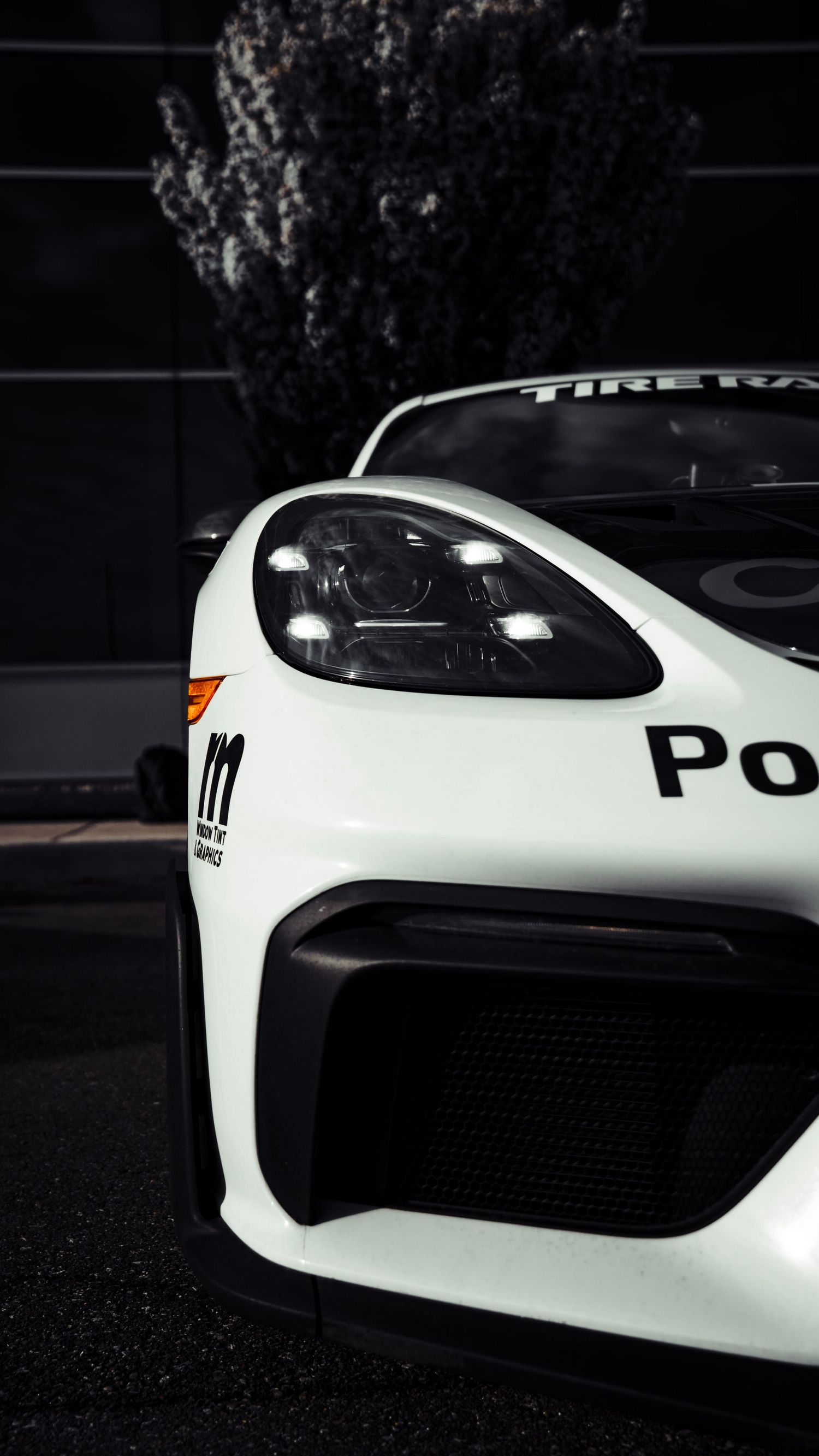 Front detail shots of a white Porsche race car showing headlights and grille.