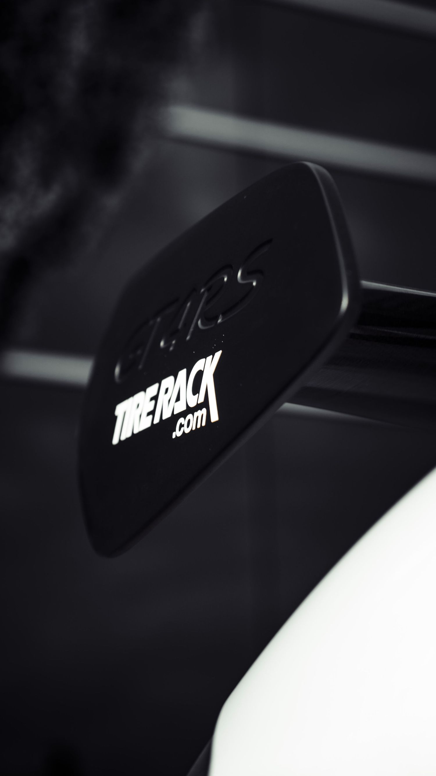Close-up detail of TakeToTrack.com branding on white race car surface.