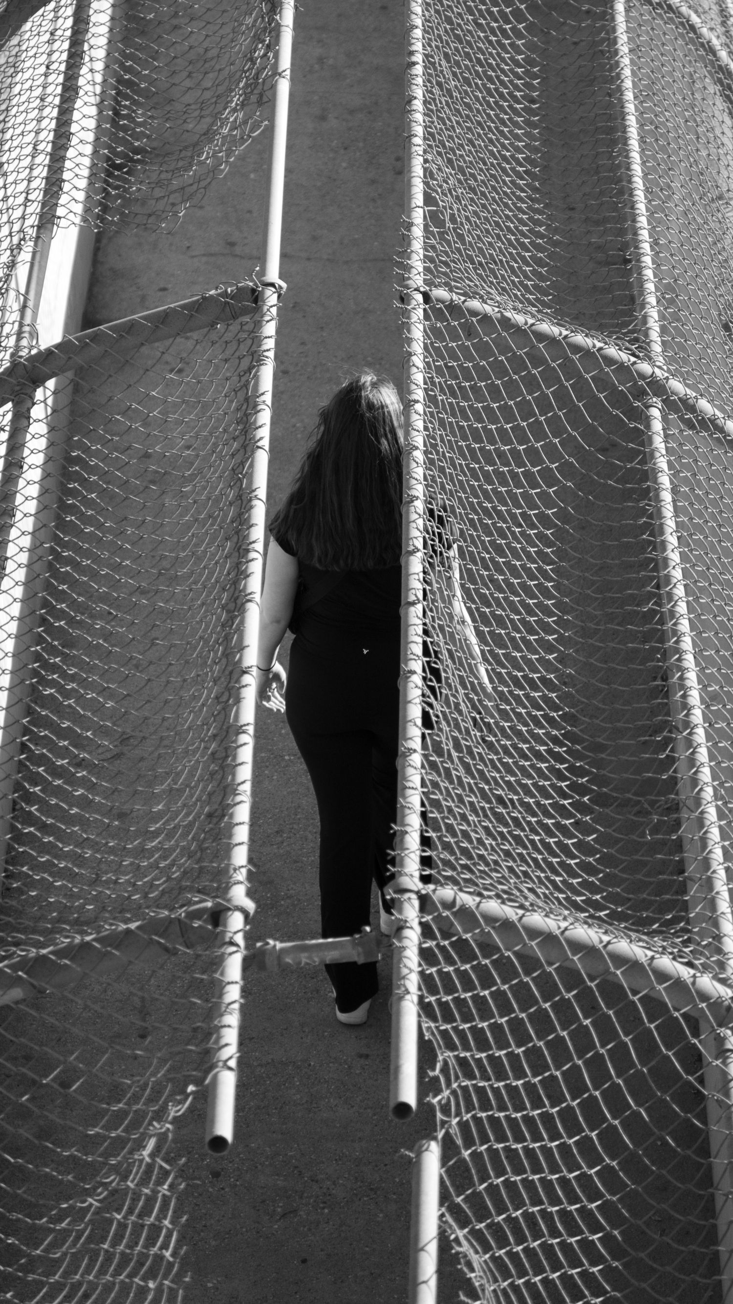 Architectural detail showing curved mesh netting structure against dark background.