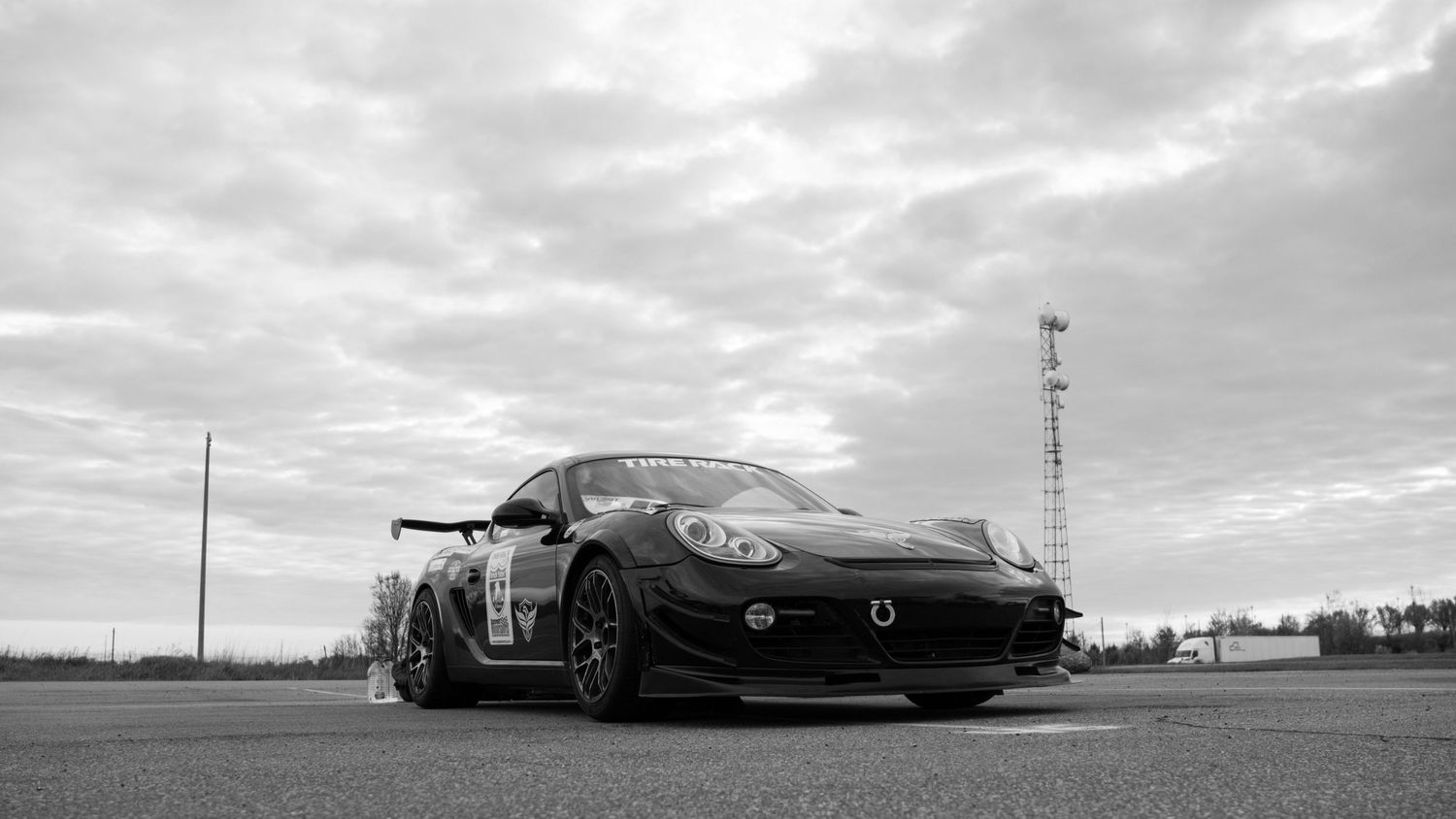 Black sports car with aggressive body kit captured in dramatic black and white.