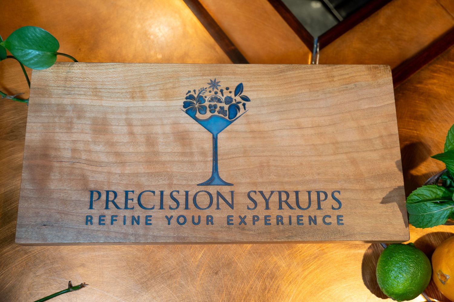 Wooden box with Precision Syrups logo and fresh limes.