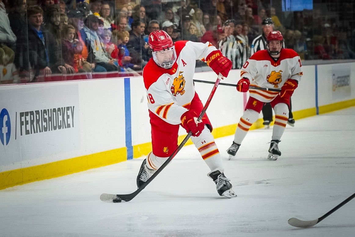 Hockey players in red and black jerseys compete for the puck during an intense game on the ice.