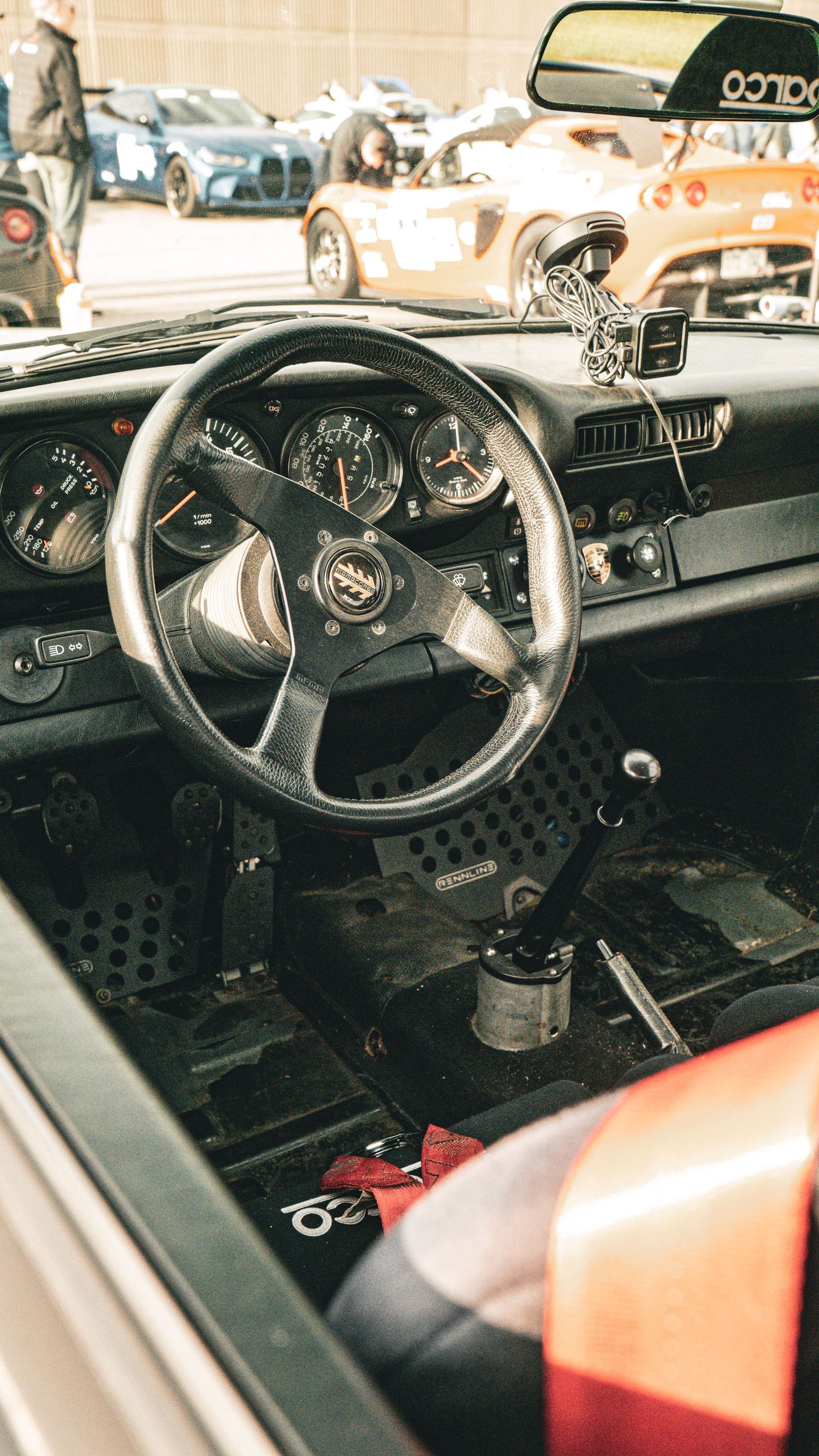 Interior dashboard view of a vintage Porsche 911 showing racing gauges and steering wheel.