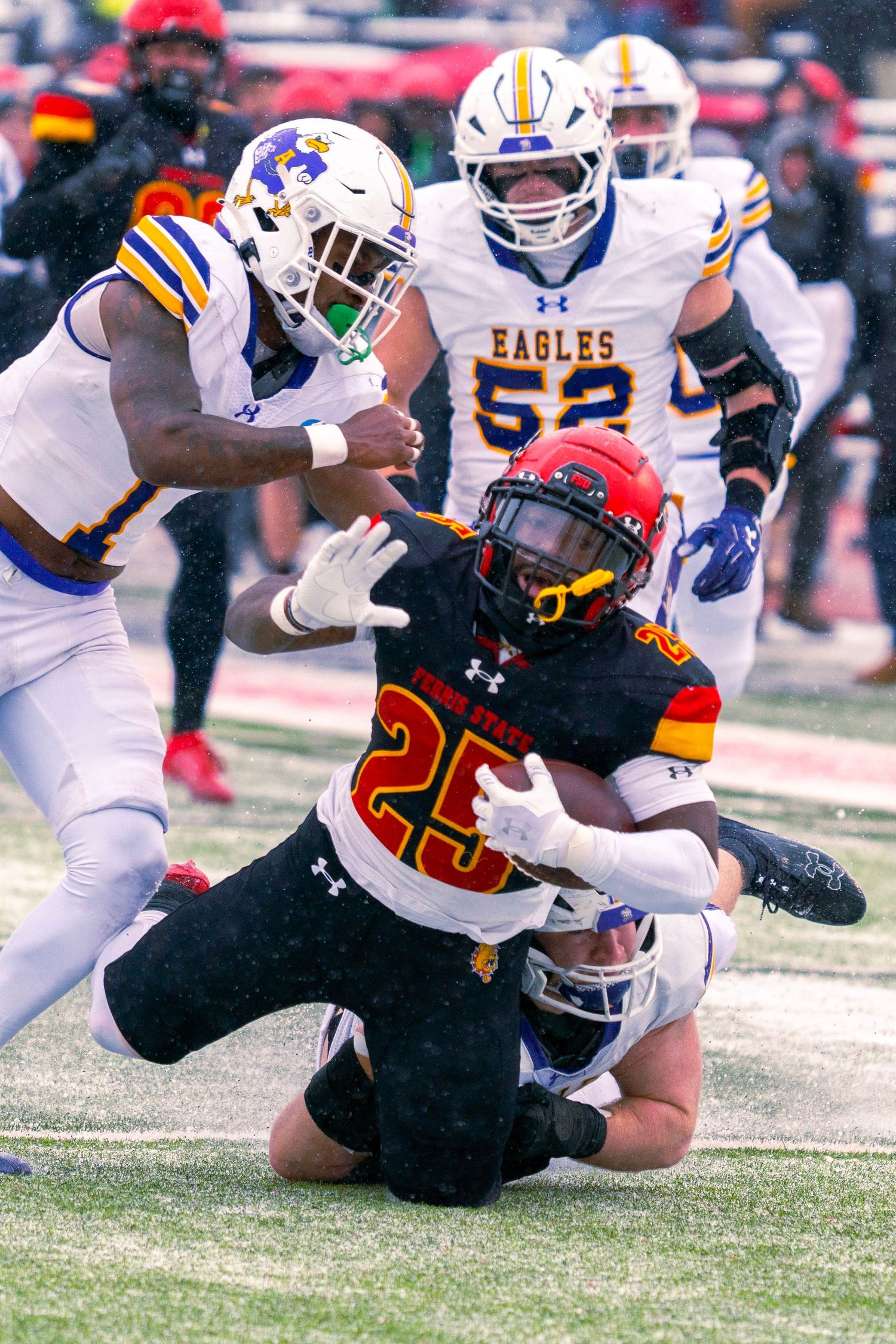 College football players tackle opponent during intense ground play in a Maryland Terrapins game.
