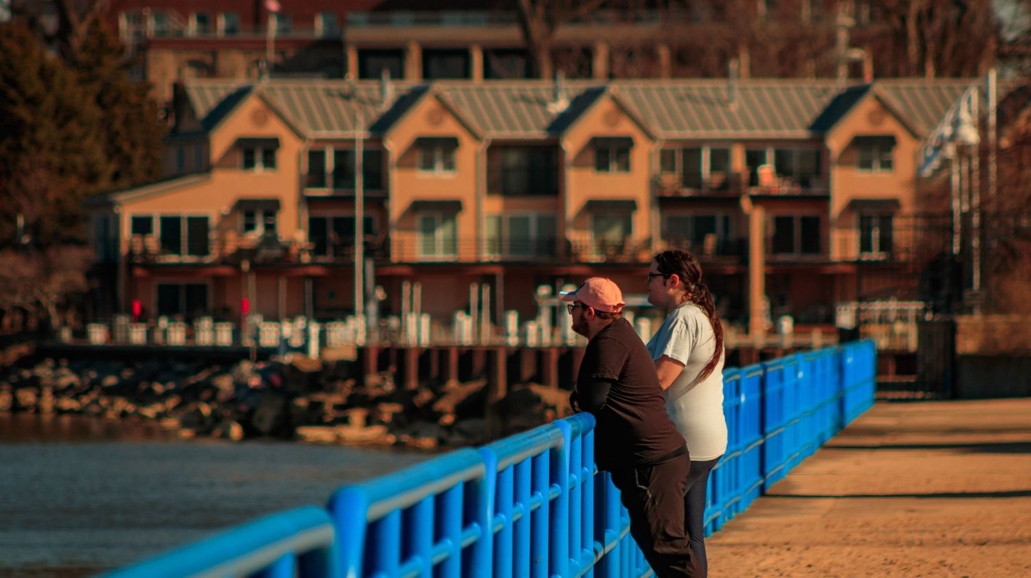 Winter scene with townhouses and a blue pier railing at a lakeside resort.