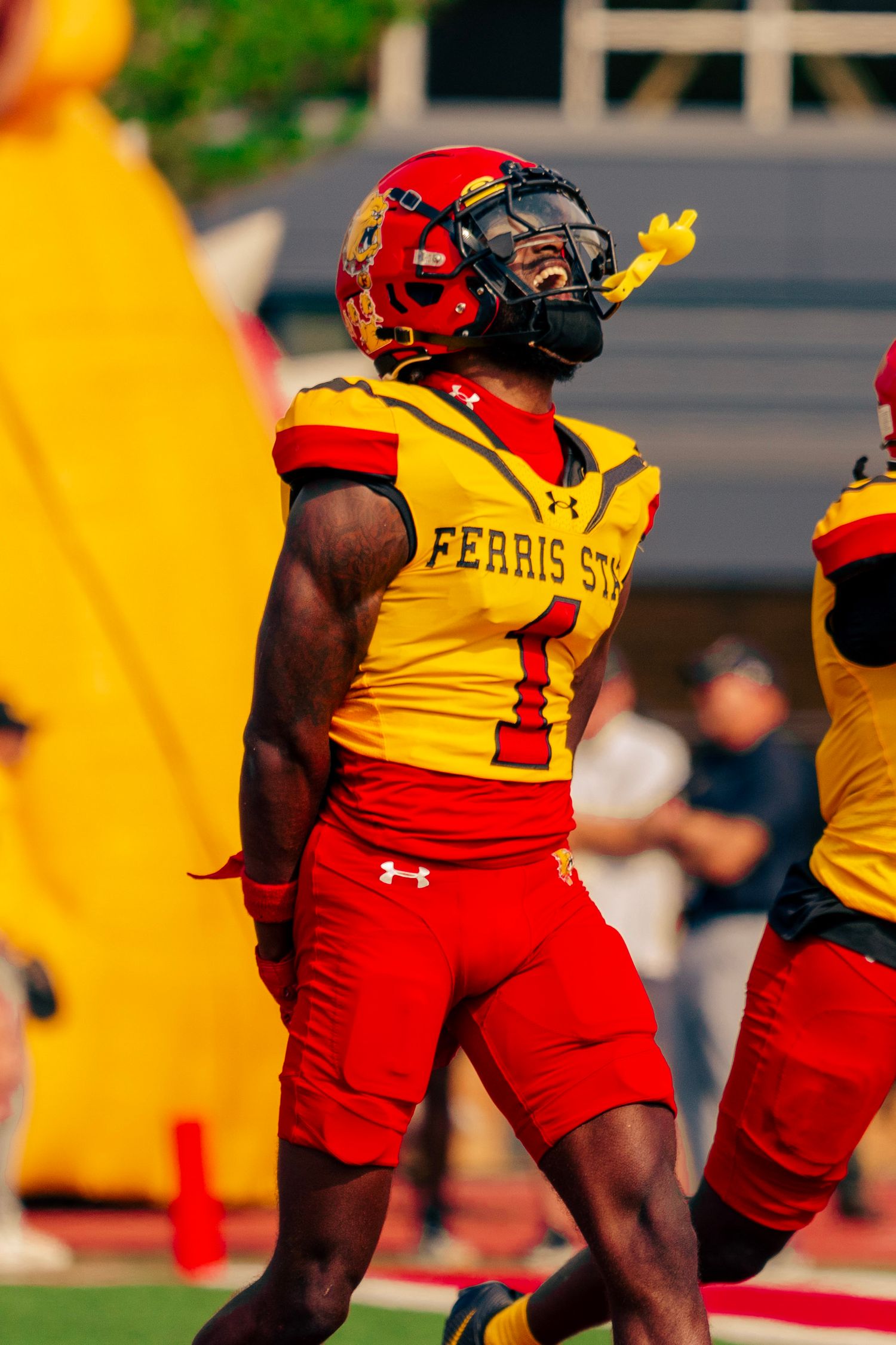 Football players in yellow and red uniforms line up during a game at Ferris State University.