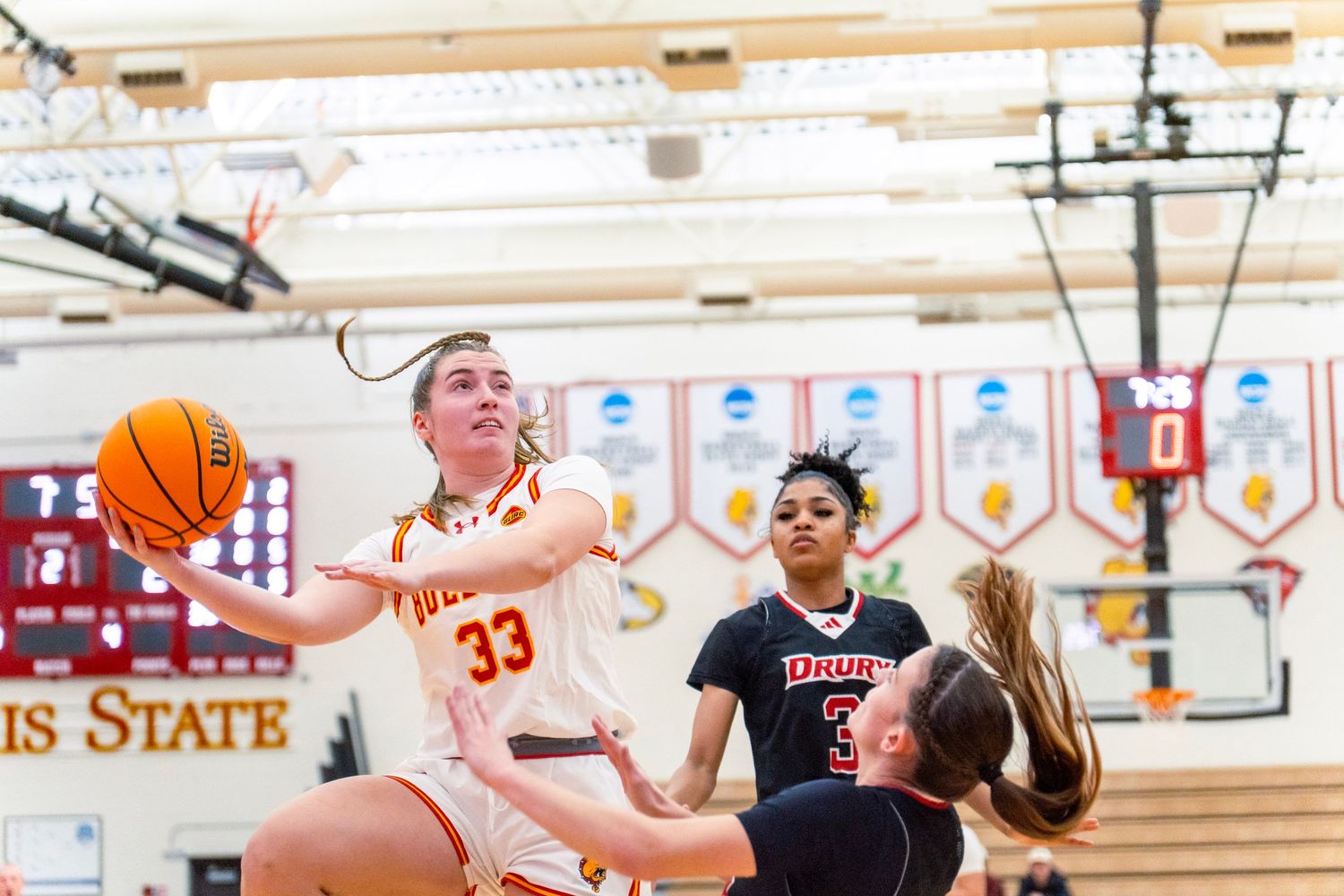 High school basketball players compete for the ball during an intense game between two teams.