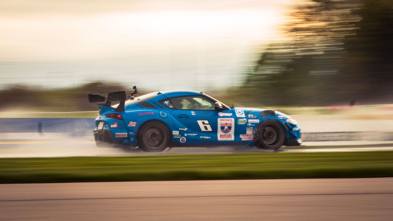 Racing vehicles creating artistic motion blur streaks during a competition.