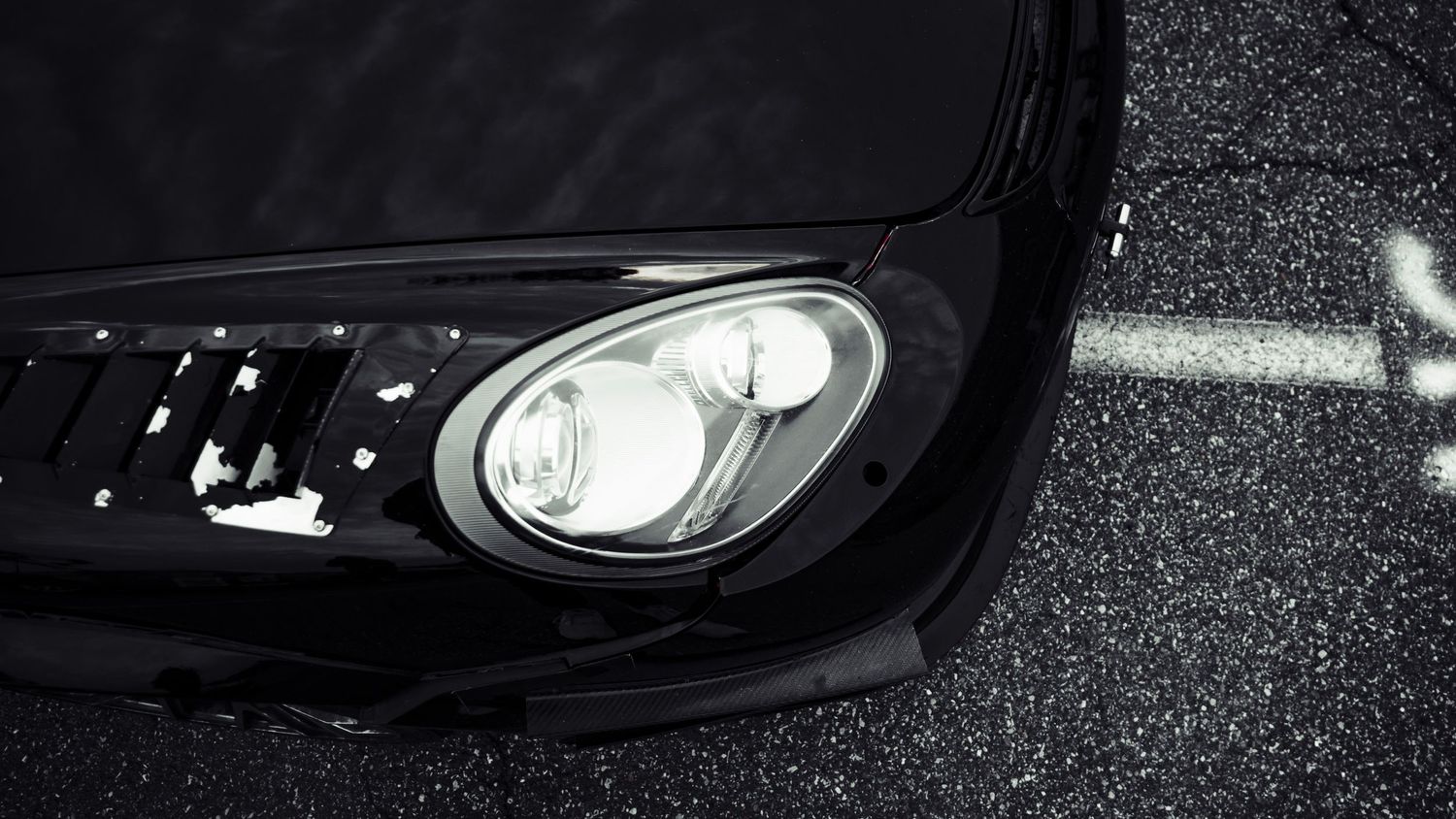 Close-up of sleek black car headlight with modern LED design.