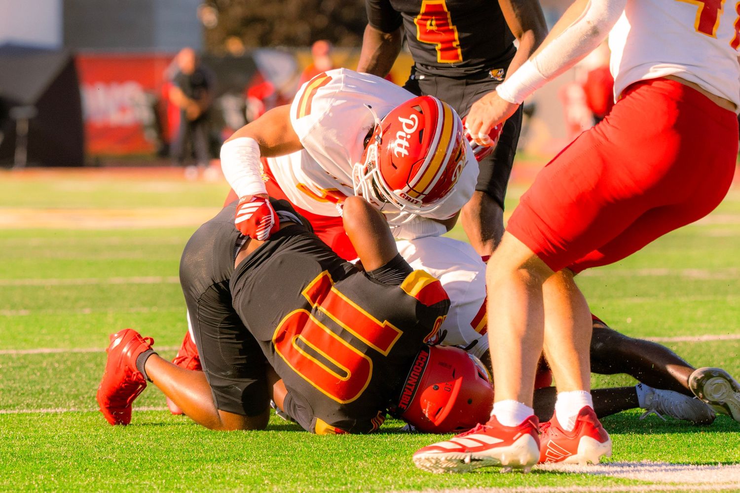 Compilation of football players in red jerseys kneeling on a sports field during a practice or game session.