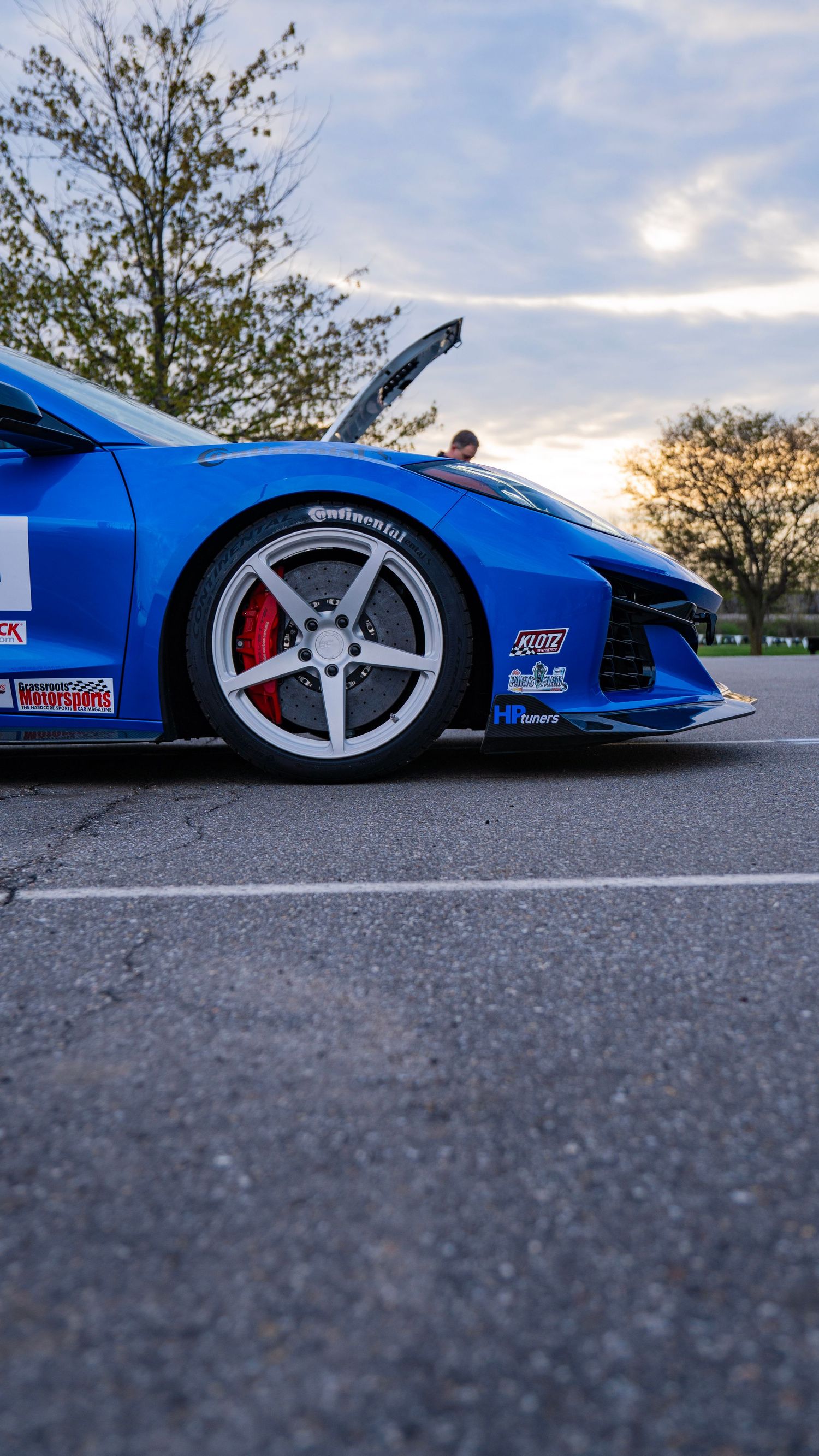 Side profile of blue racing Supra with custom wheels and aerodynamic modifications.