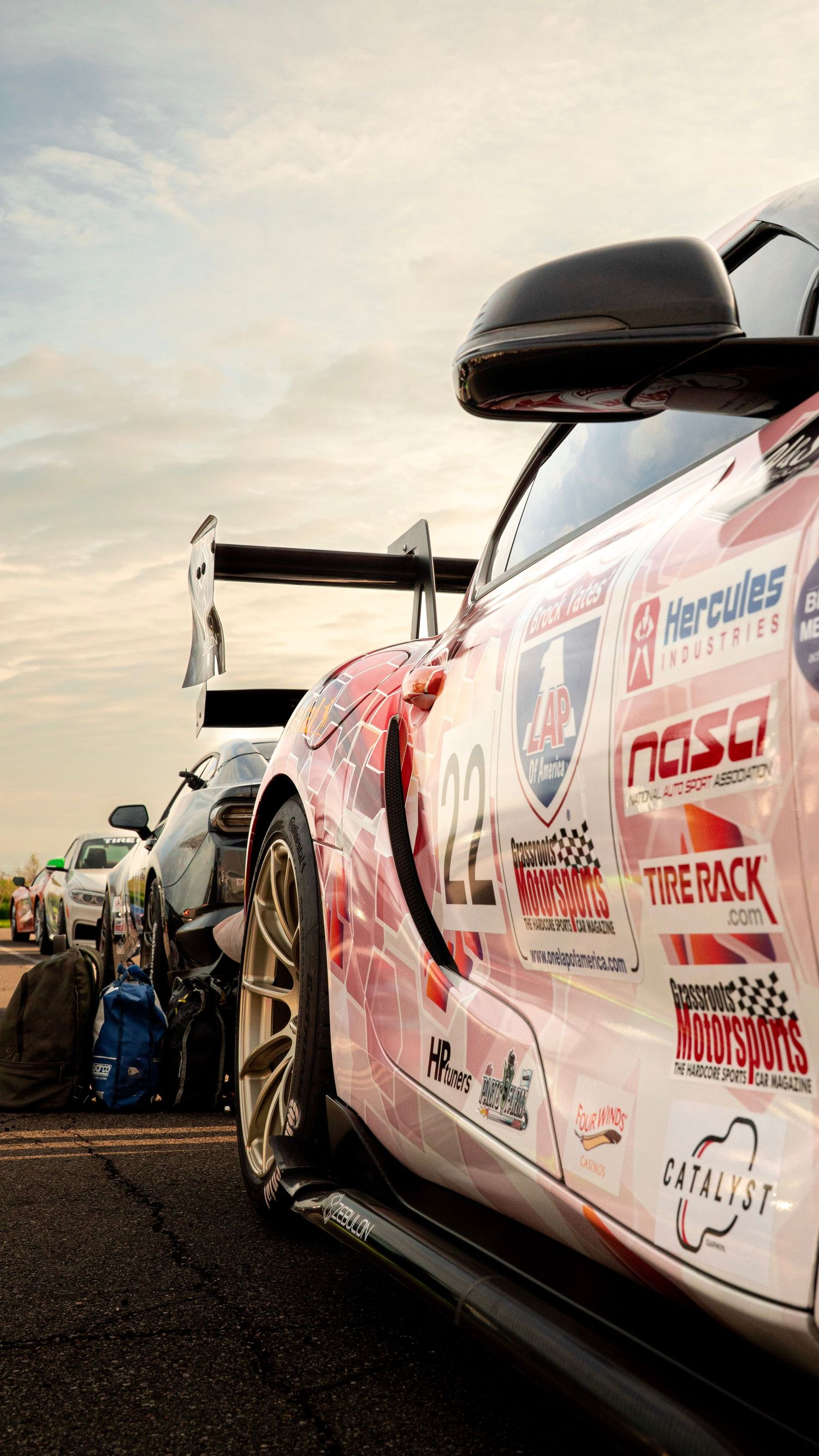 Race car with white and pink livery showing sponsor decals and racing modifications.