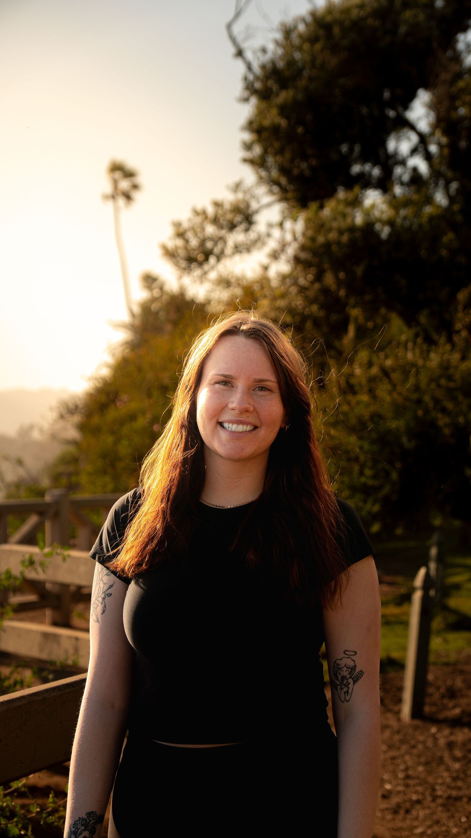 Portrait taken during golden hour with trees and sunset in background.