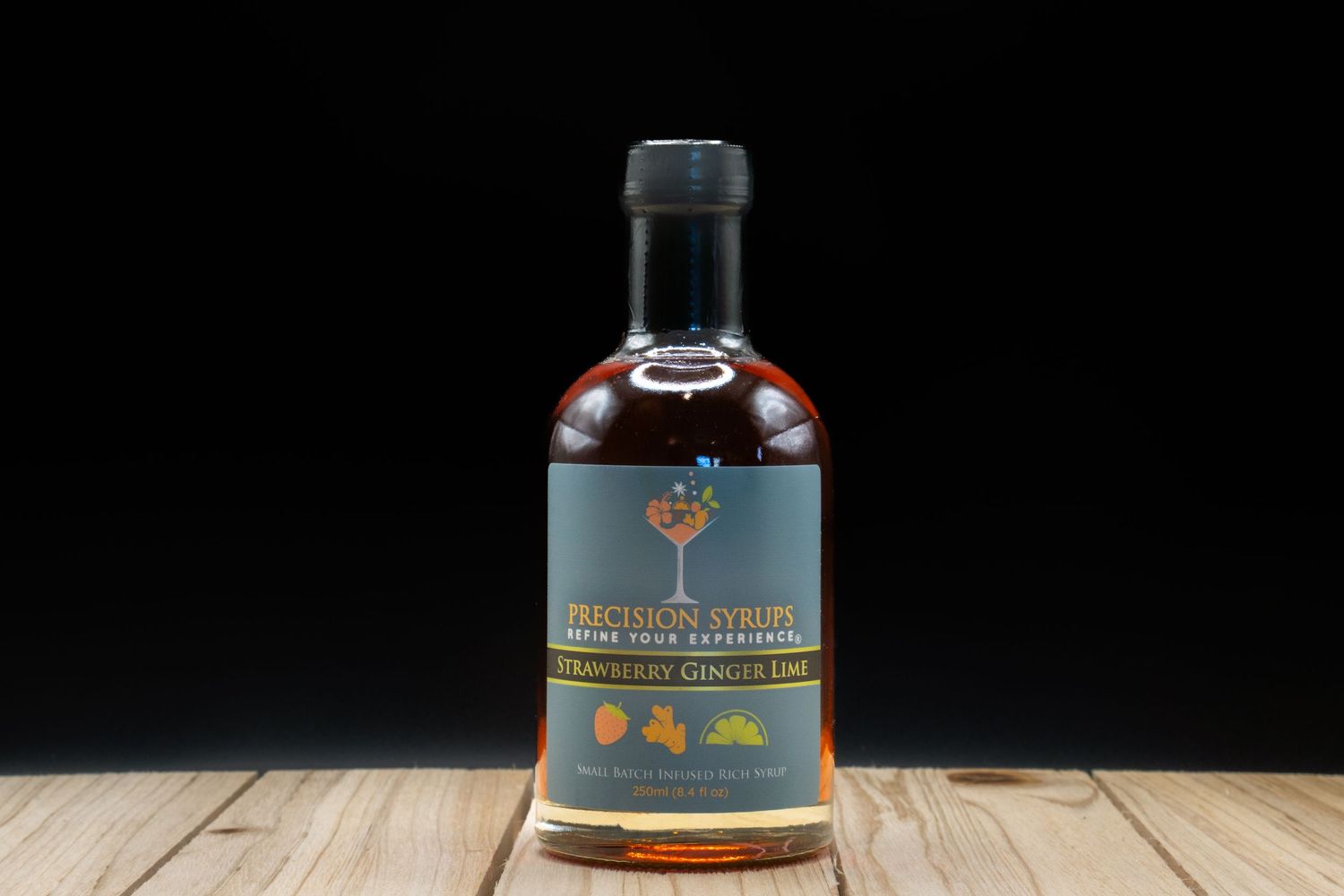 Premium dark liquor bottle with black cap and tree logo on wooden surface against dark background.