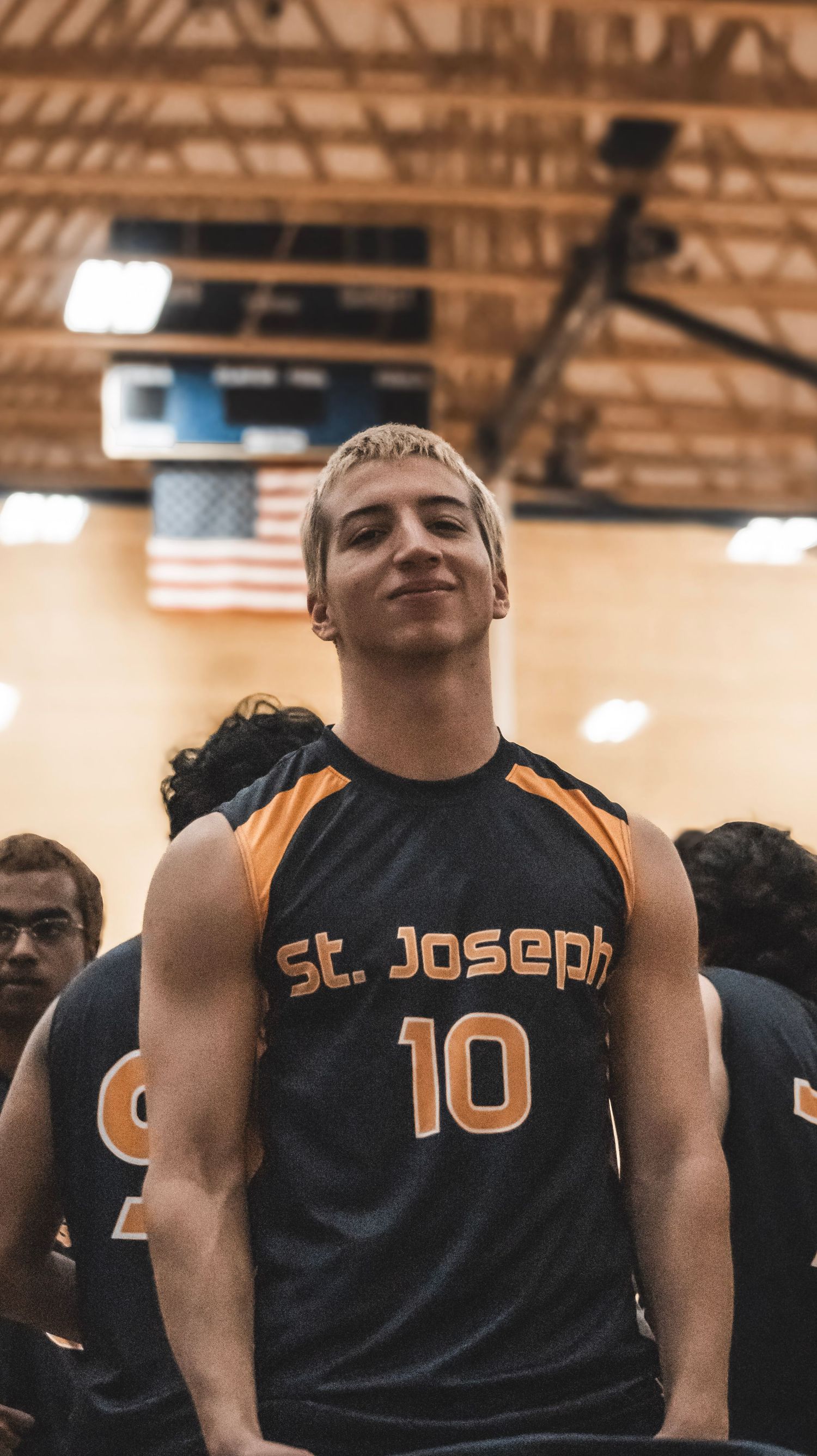 Player wearing St. Joseph number 10 jersey stands in school gymnasium.