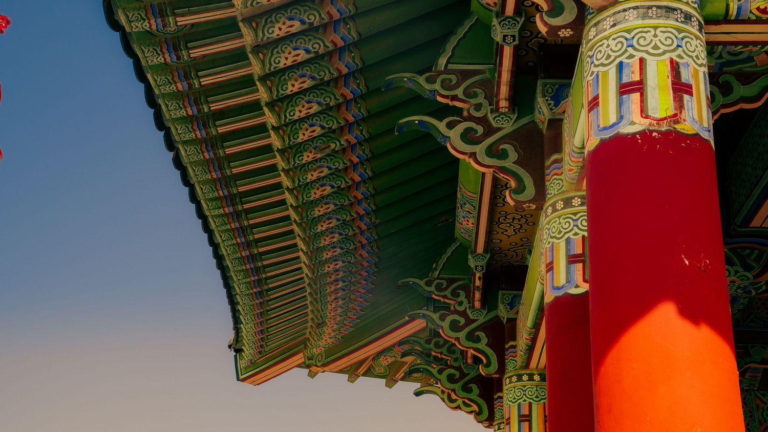 Close-up detail of colorful painted designs on traditional Korean temple roof beams.