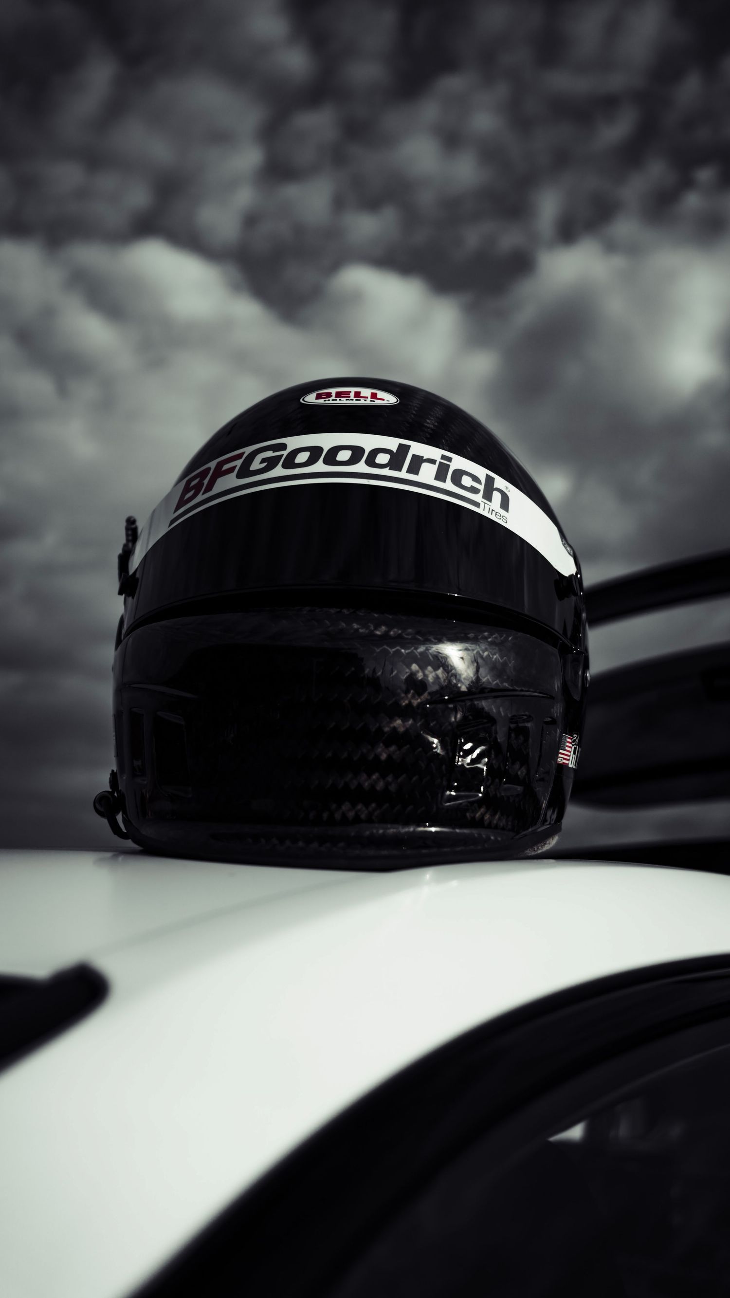 Dramatic black and white image of BFGoodrich racing component on car surface.