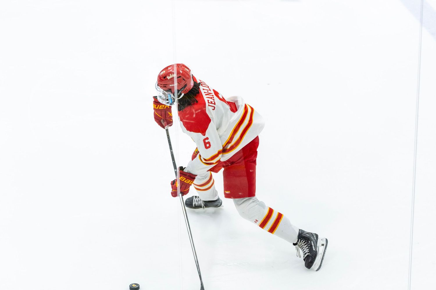 A sequence of hockey players in red and white jerseys performing skating maneuvers on ice during practice.