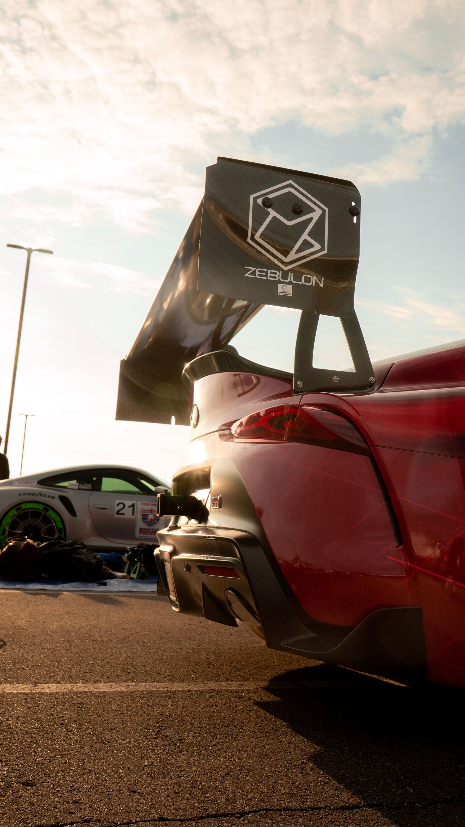 Low angle shot of sports cars with Zebulon branded wing at sunset.