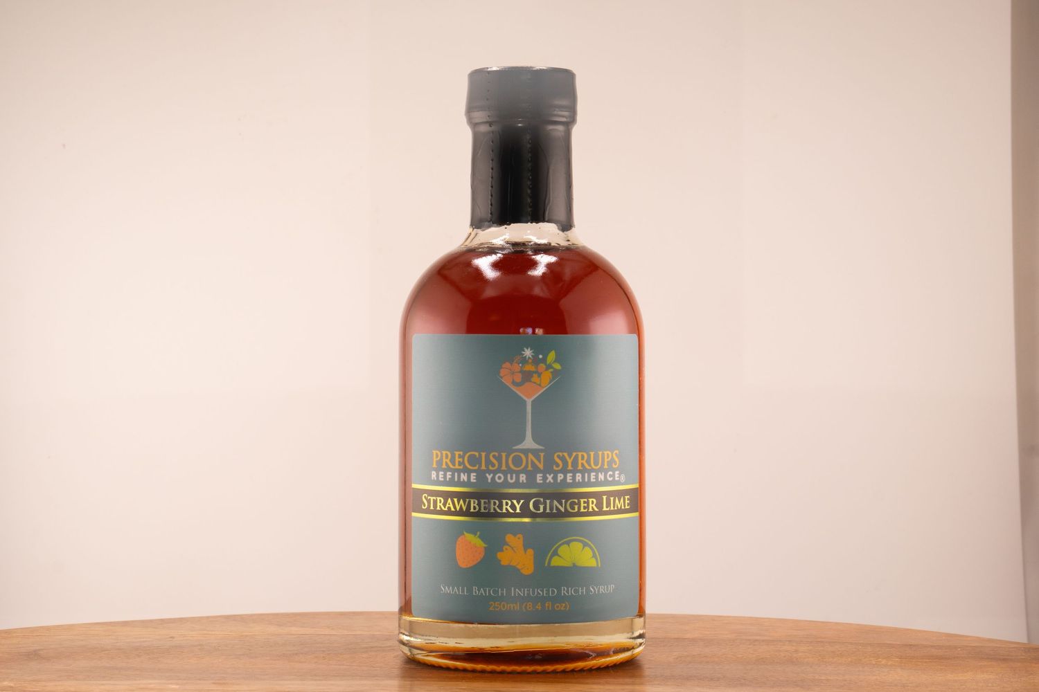 Premium spirits bottle with red-tinted liquid and tree logo displayed on wooden surface.