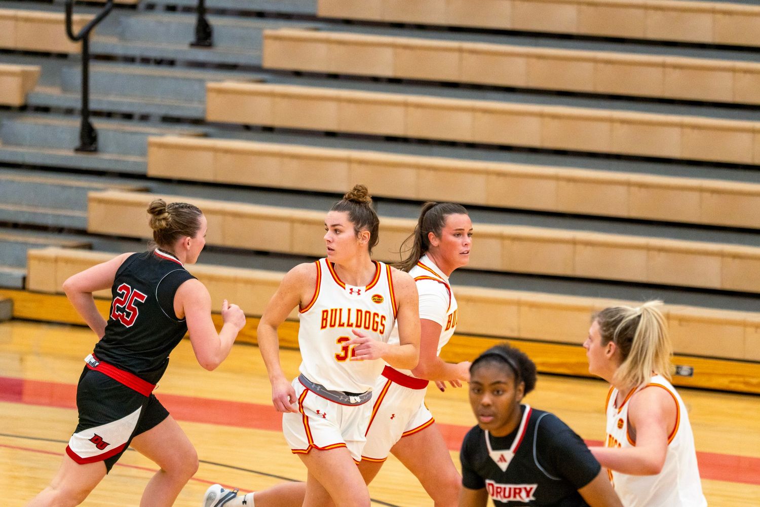 Basketball players from opposing teams compete for possession during an intense game on the court.