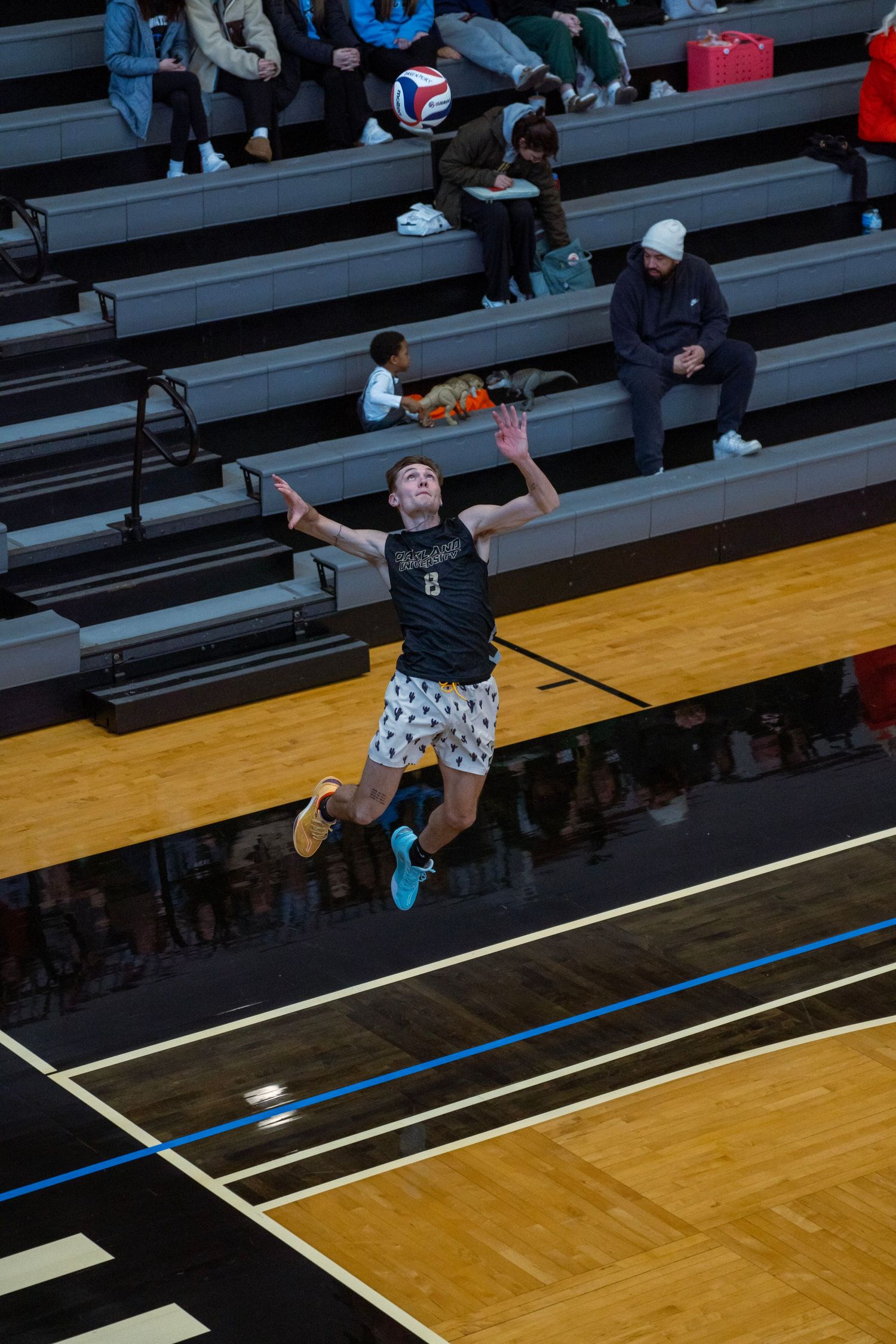 A sequence of five action shots showing a volleyball player diving and rolling to save a ball during a match.