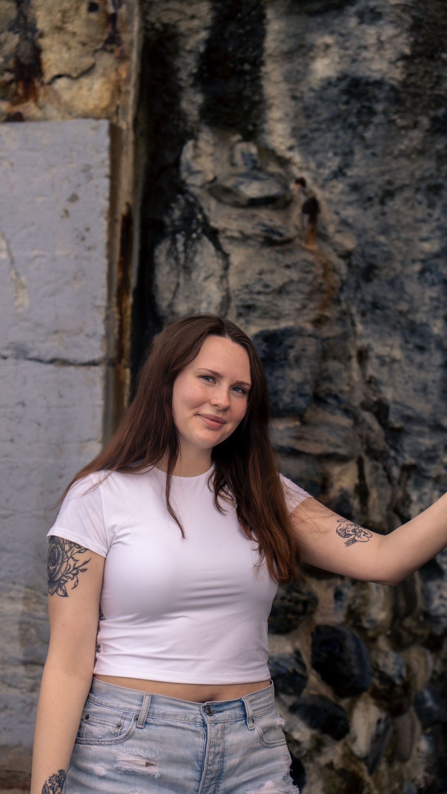 Casual summer fashion shoot featuring white crop top and distressed denim shorts.