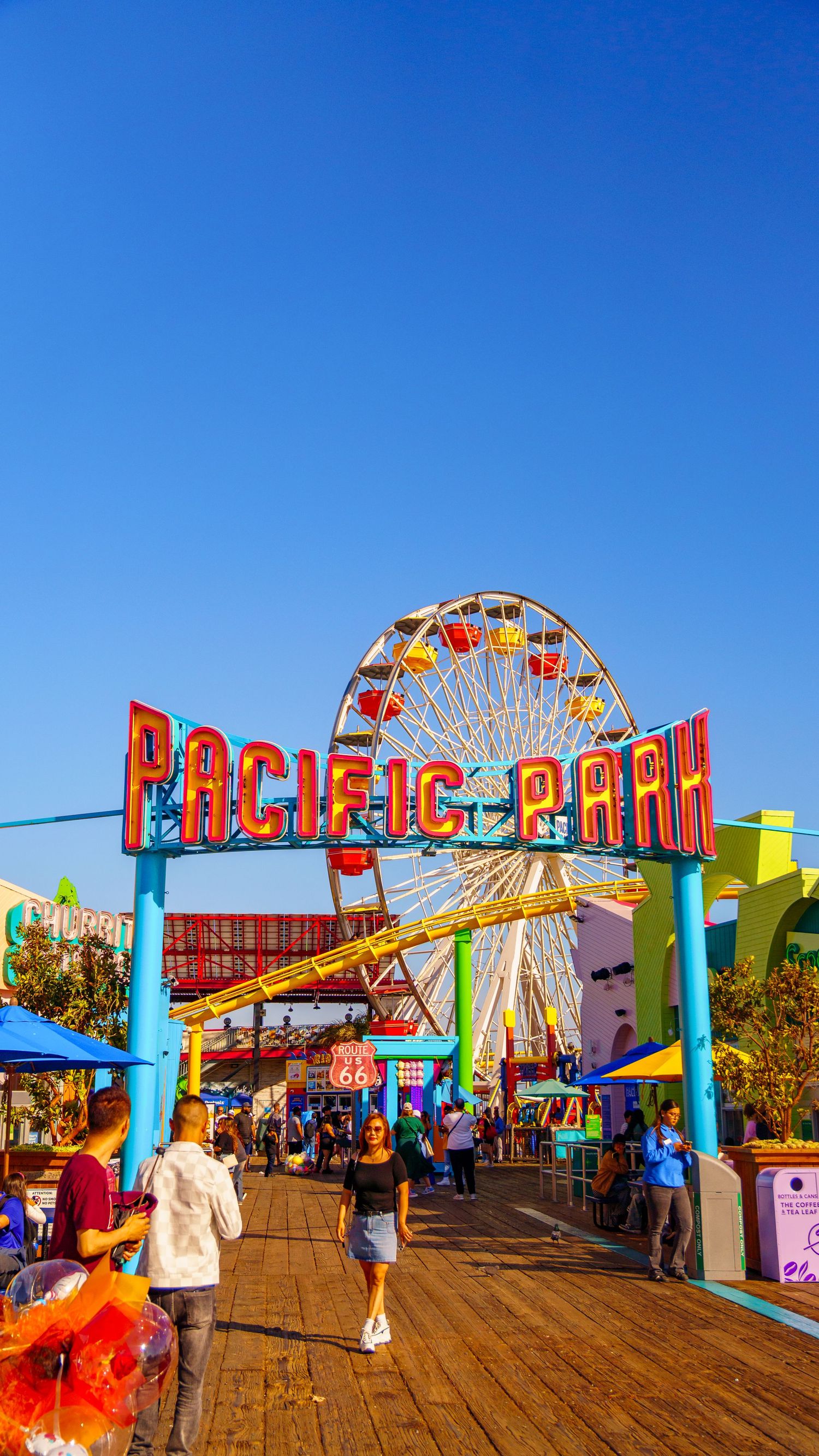 Pacific Park entrance arch with Ferris wheel visible through colorful gateway on Santa Monica pier.