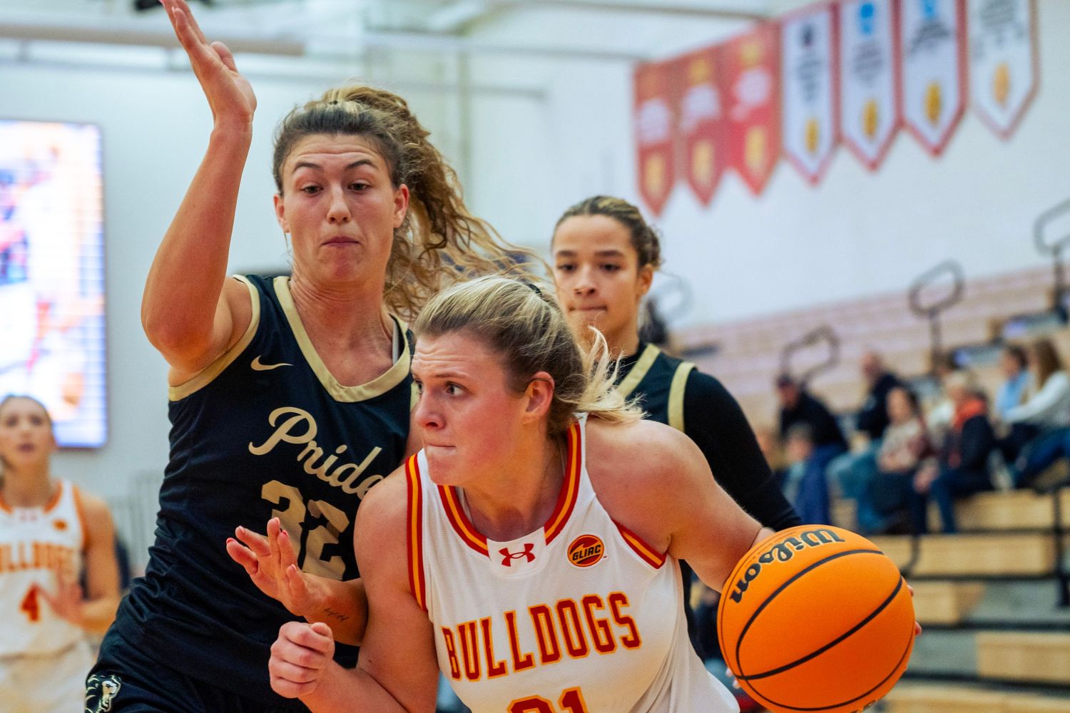 Basketball players from opposing teams compete for possession of the ball during an intense game.