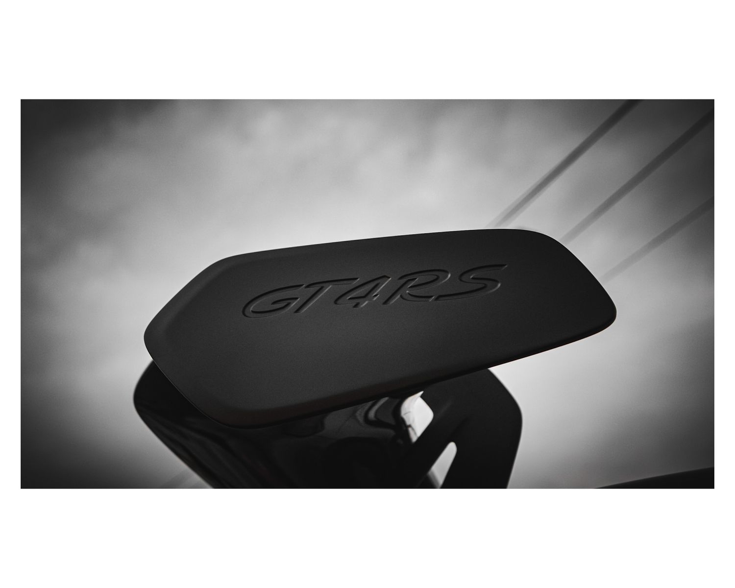 Black GT4RS logo embossed on dark automotive surface.
