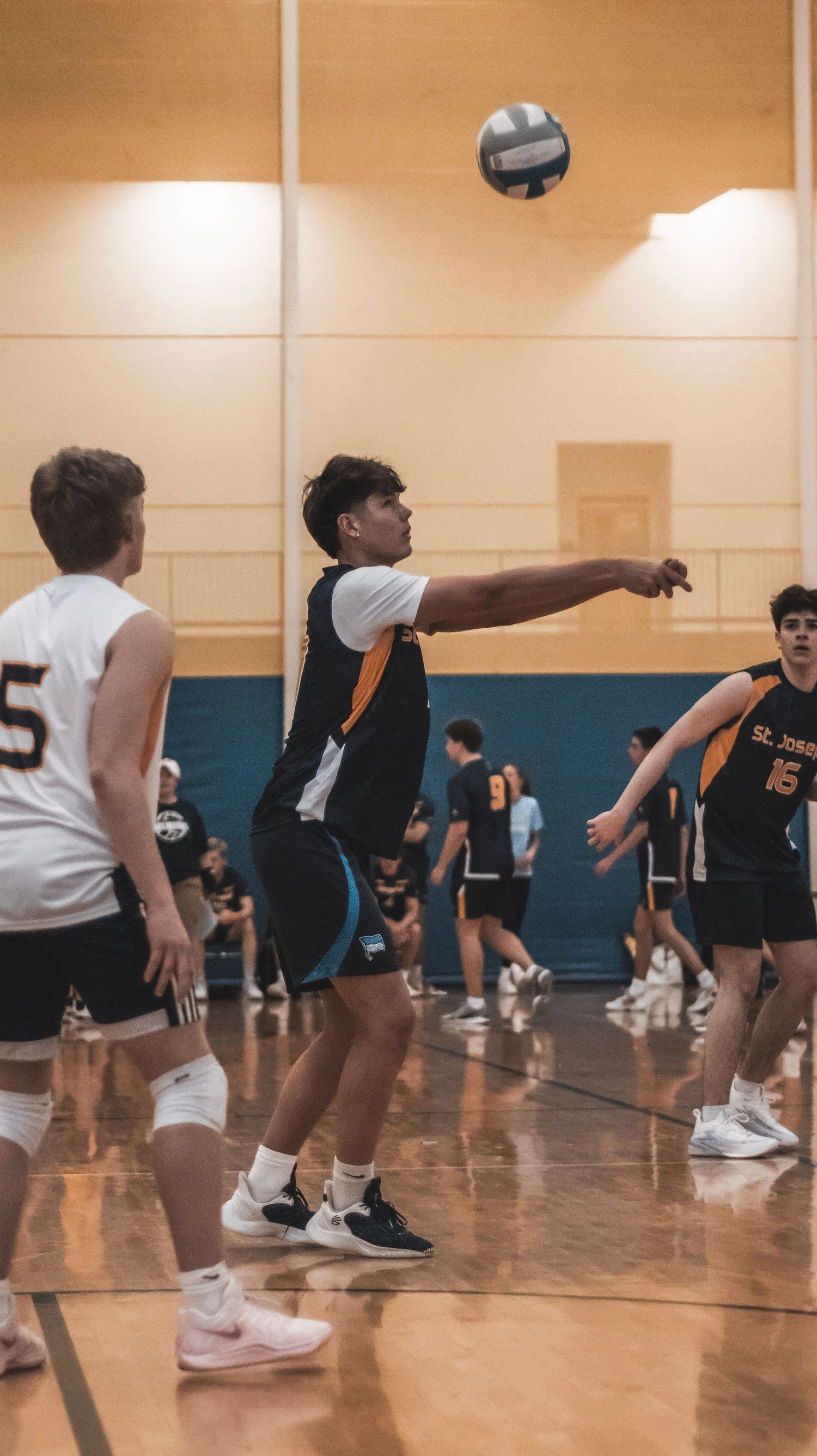 Players from opposing teams compete for the ball during a volleyball match.
