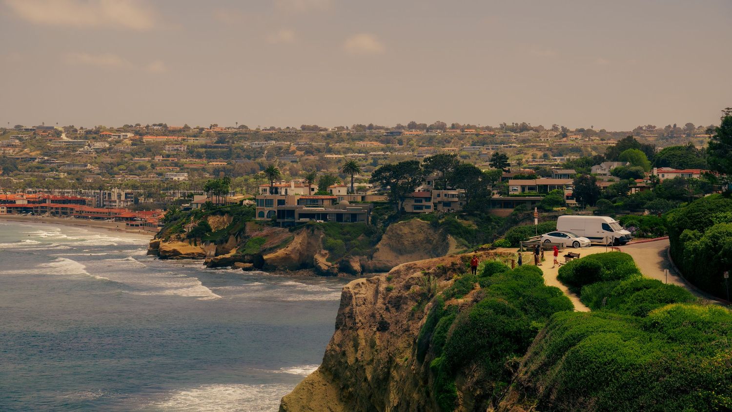 Scenic coastal town built along rugged cliffs overlooking Pacific Ocean.