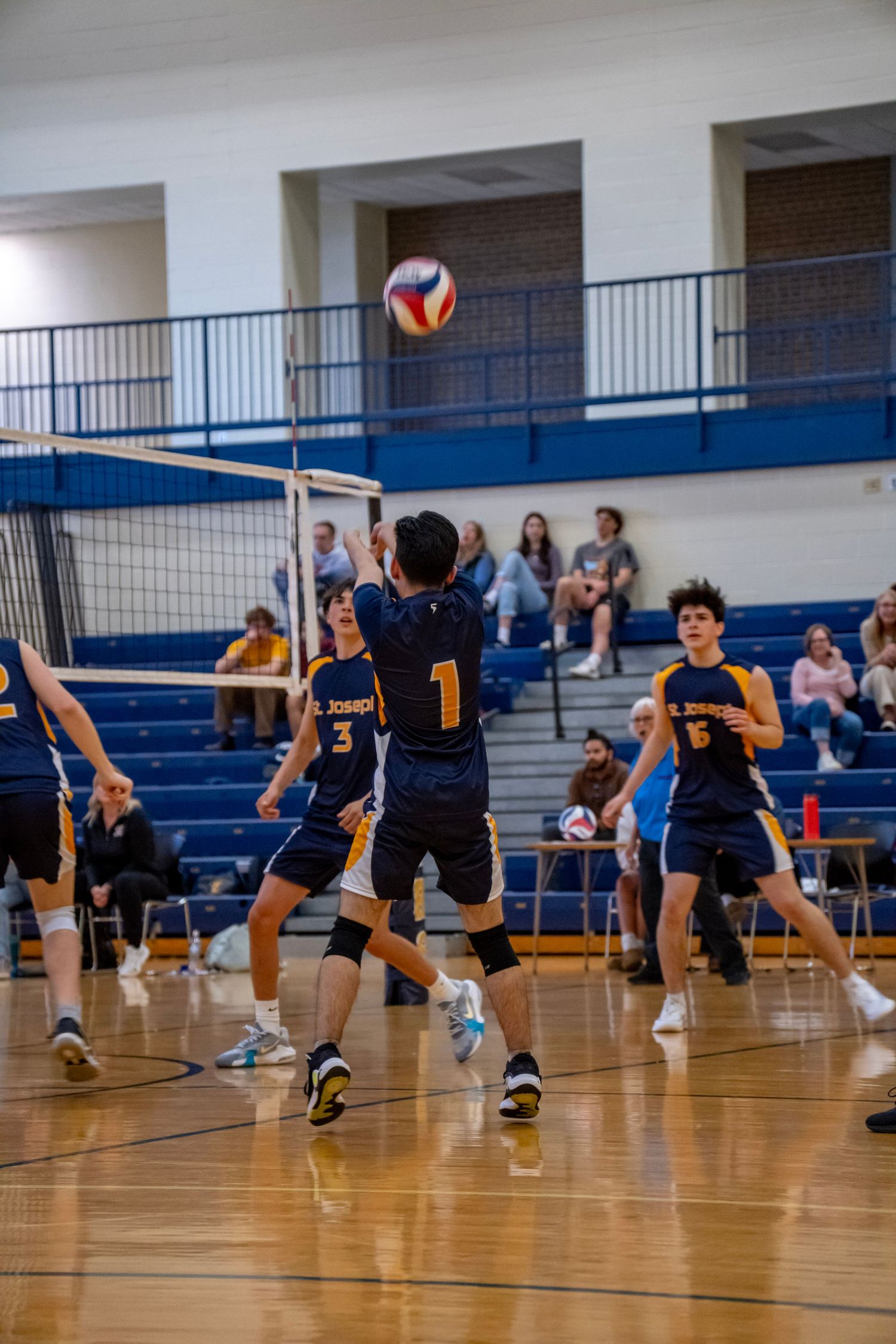 Volleyball players dive and stretch to save a ball during an exciting rally.
